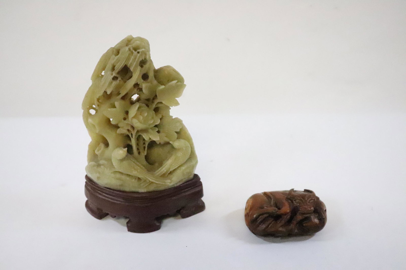 A shoushan stone carving, and a wood carving: A shoushan stone carving (5.25"H) depicting birds and flowers, and a wood carved water buffalo (2.35"x1.6"x1")