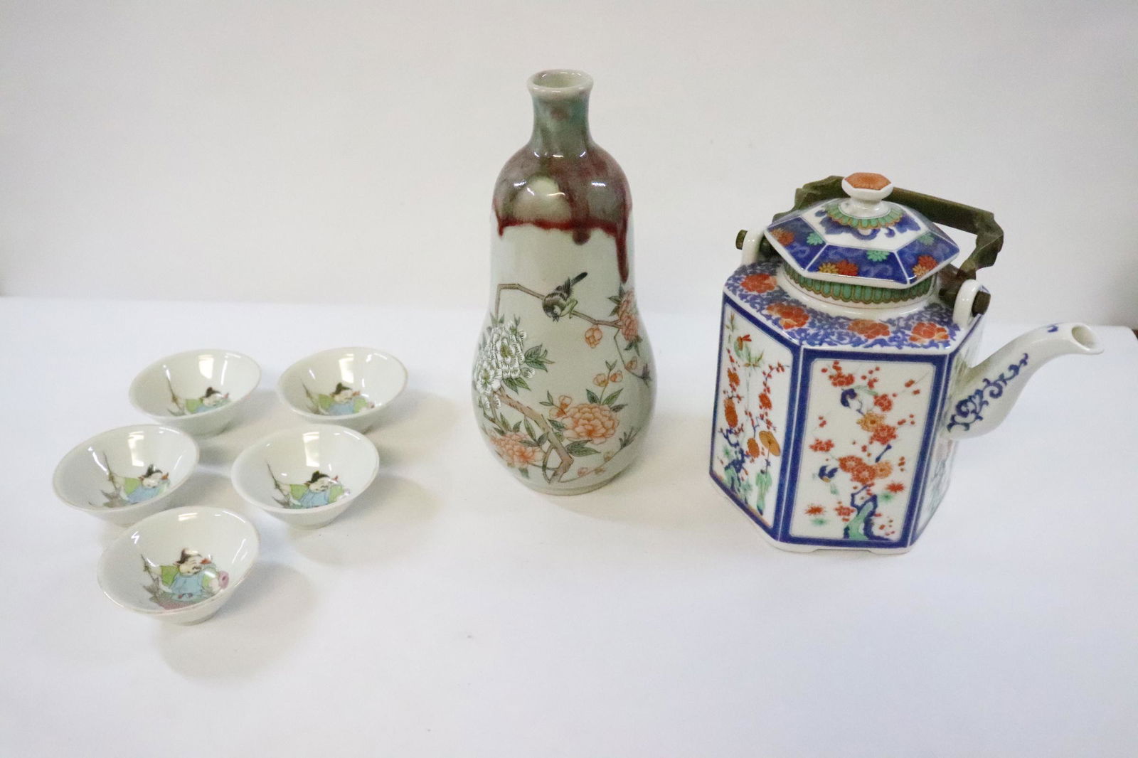 7 misc. porcelain pieces: Famille rose porcelain vase (8.65"Hx3.75"dia), a wucai teapot (8"Hx6.8"x5"), and 5 small porcelain tea cups (1.25"Hx3"dia each)