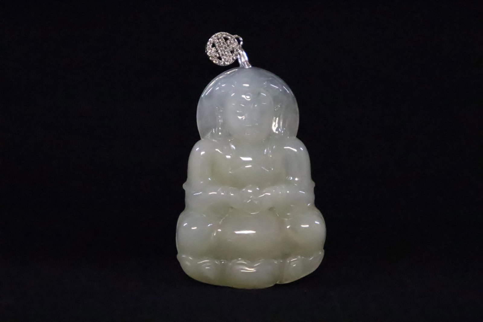 A translucent jadeite carving made as pendant: A fine translucent jadeite carved deity made as pendant, 2.15"x1.45"x0.2"