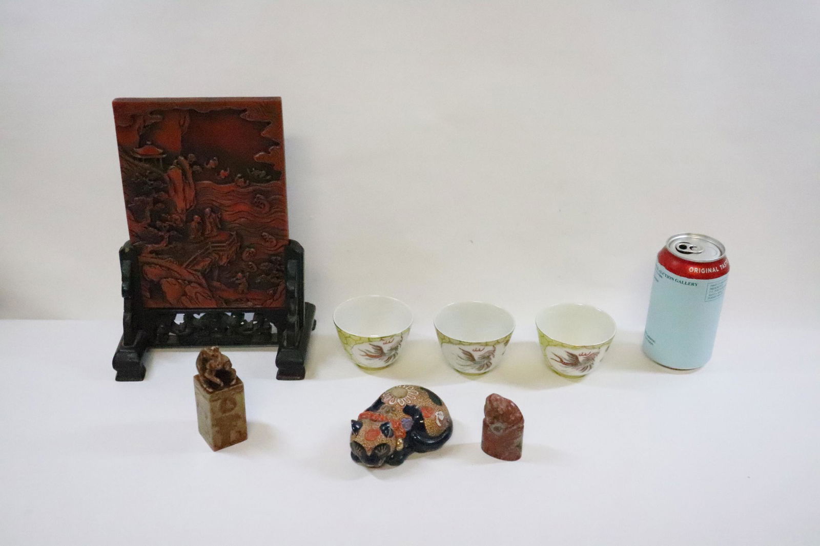 lot of misc.: 2 Chinese shoushan stone seals (2.3"H, 3.75"H), kutani cat (3.9"L), 3 tea cups (2.13"Hx2.95"dia each) and a simulated cinnabar plaque (8.05"x5.65"x0.45") on stand
