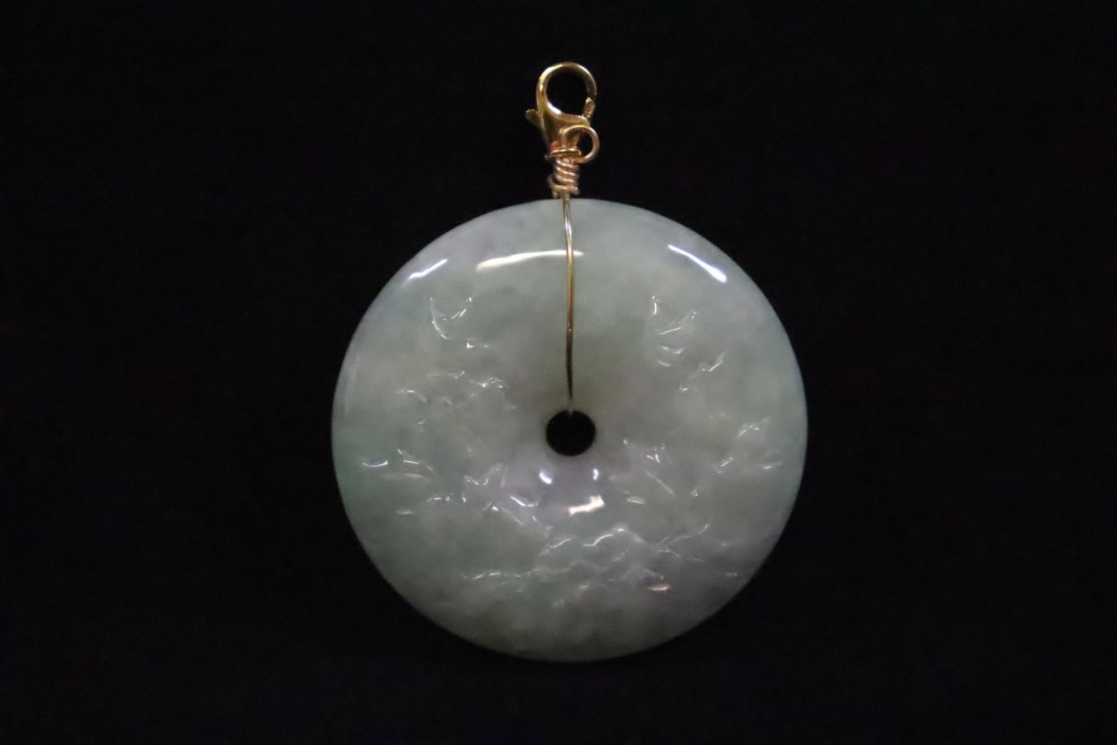 A fine jadeite carved disc, made as pendant: A fine jadeite carved disc, made as pendant measures approx. 49x12.8mm