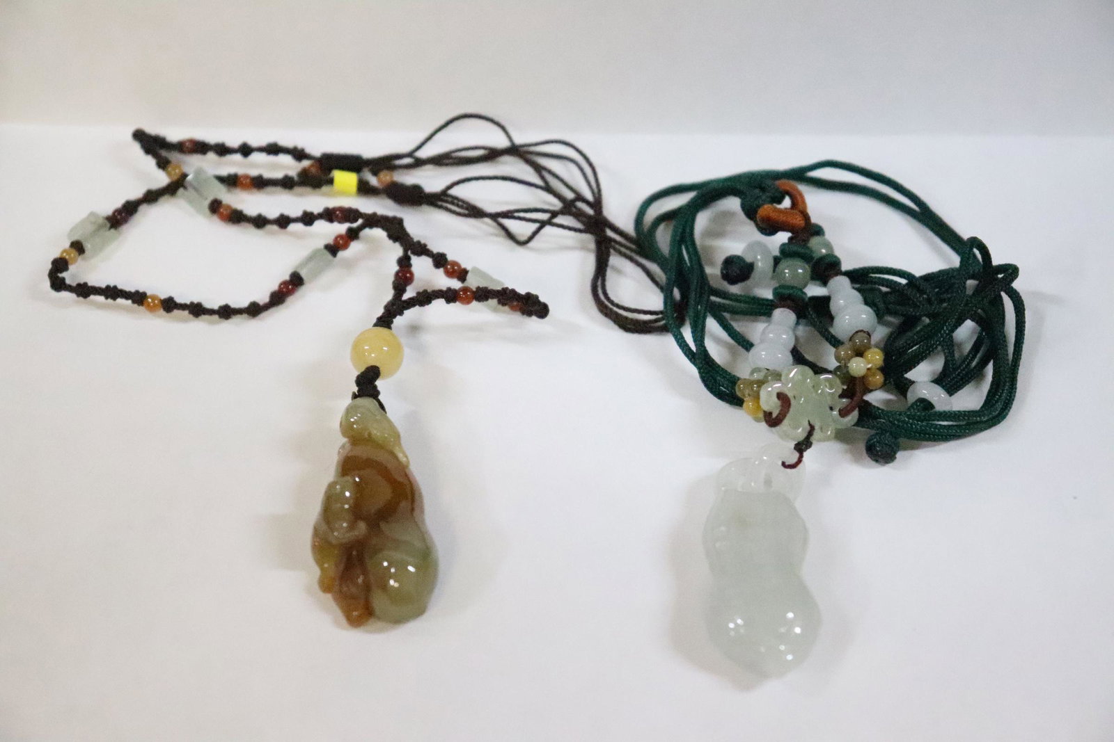 2 jadeite carved pendant attached to necklaces: 2 jadeite carved pendant (1.6"x0.7"x0.45", 1.6"x0.7"x0.55") attached to necklaces