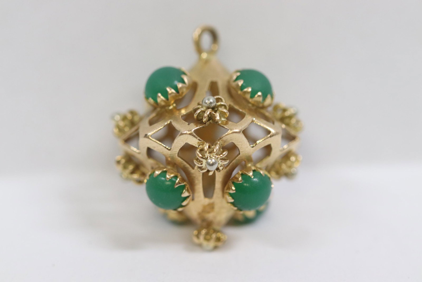 18K cage pendant set with 8 green stones: 18K cage pendant (0.83"dia) set with 8 green stones, possible jadeite, wt. 6.5gm