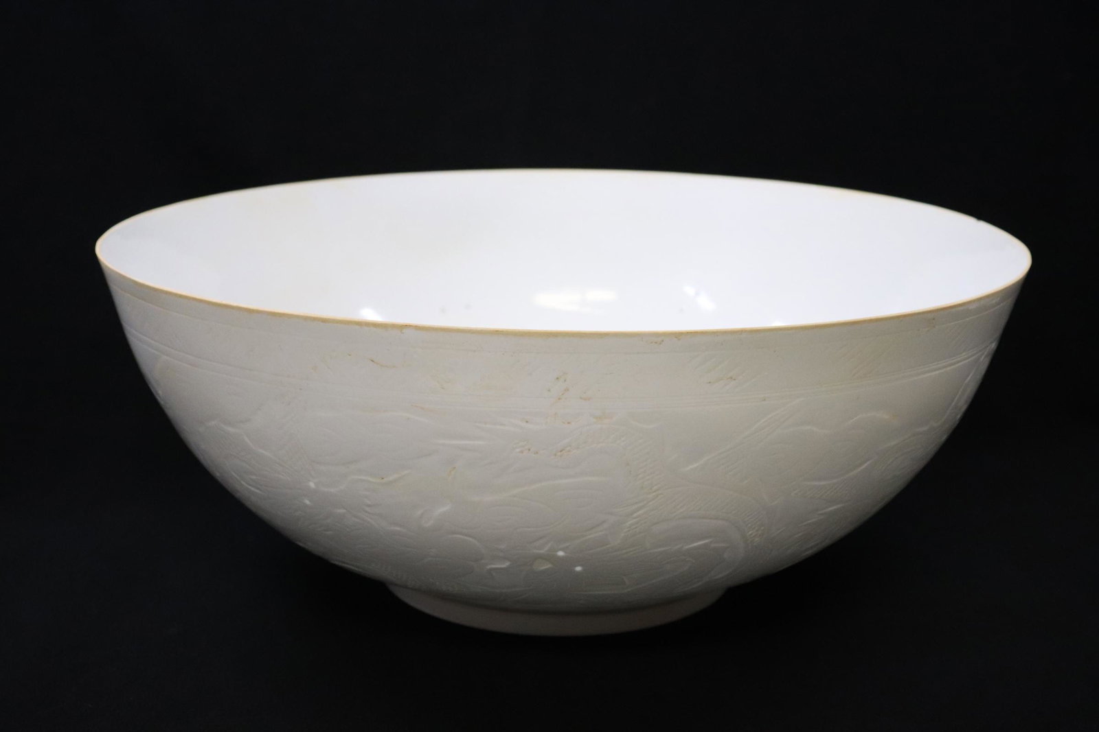 A large Chinese white eggshell porcelain bowl: A large Chinese white eggshell porcelain bowl embossed with dragon motif decoration, 5.8"Hx14.45"dia
