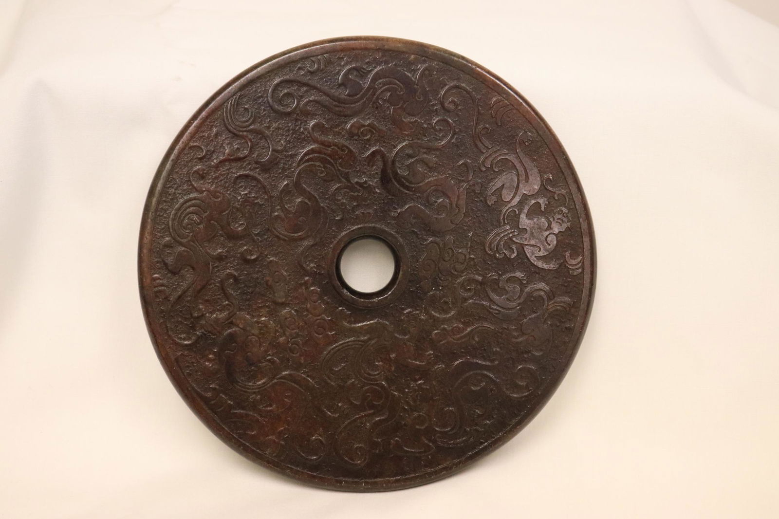 A dark celadon jade carved disc (1 of 9)