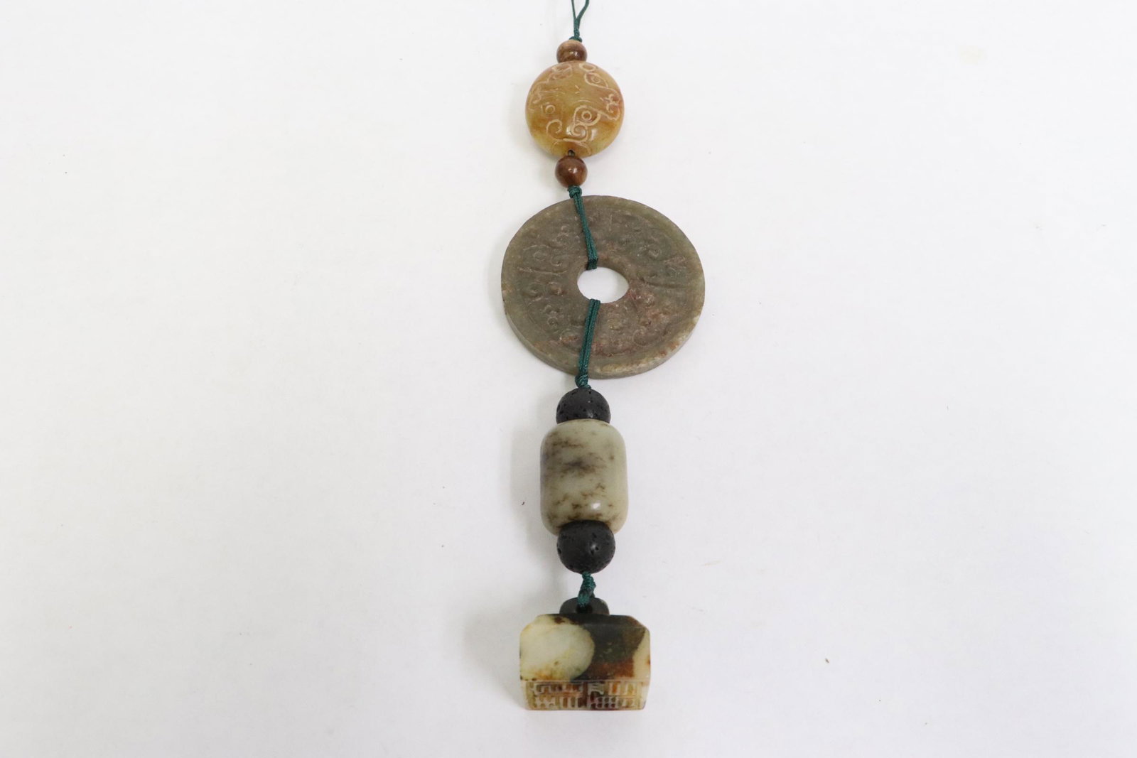 4 Chinese jade carved ornaments on a string: 4 Chinese jade carved ornaments on a string, 0.8"x1"x0.9", 0.95"x0.75"dia, 0.2"x1.9"dia, 1.2"x1"x0.65"