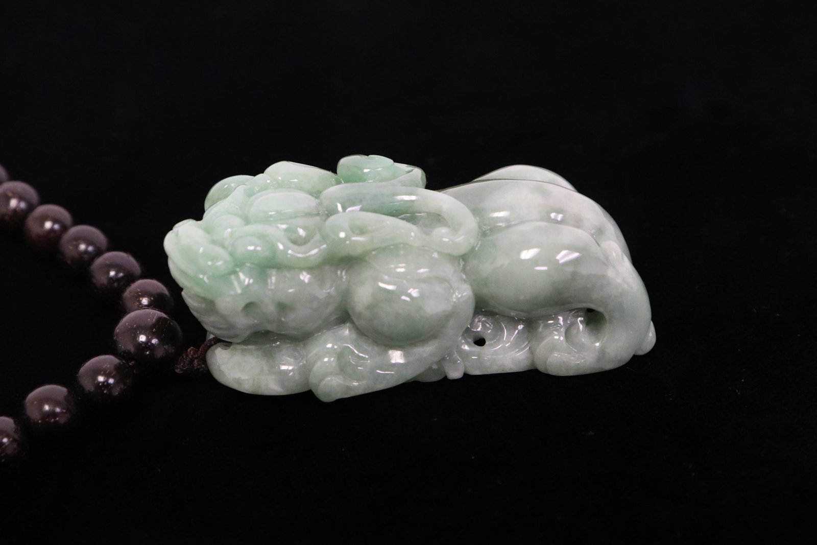 Chinese jadeite carving attached to a necklace: Chinese jadeite carved qilin (2"x0.85"x0.88") attached to a necklace