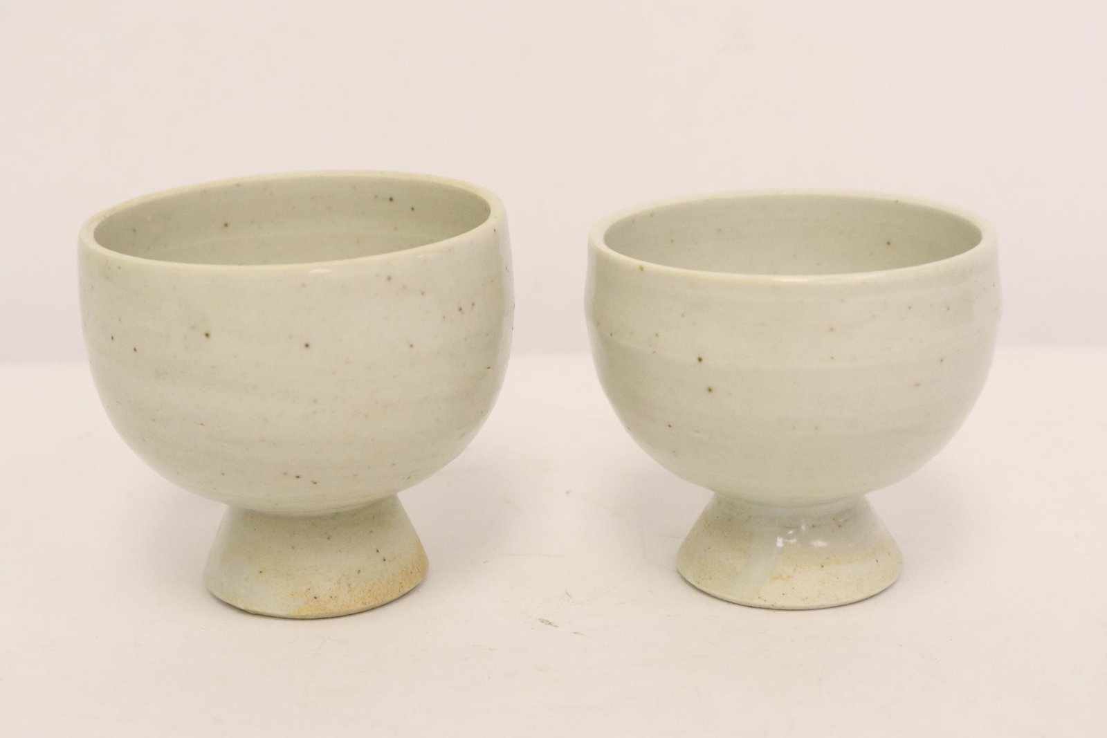 2 Korean white porcelain wine cups: 2 Korean white porcelain wine cups, 2.45"Hx2.68"dia, 2.65"Hx2.8"dia