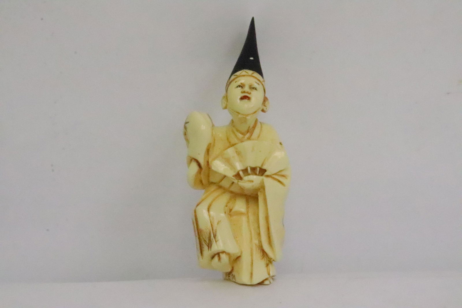 Japanese antique polychrome bone carved netsuke: A beautiful Japanese antique polychrome bone carved netsuke depicting court officer holding a fan, 2.95"H