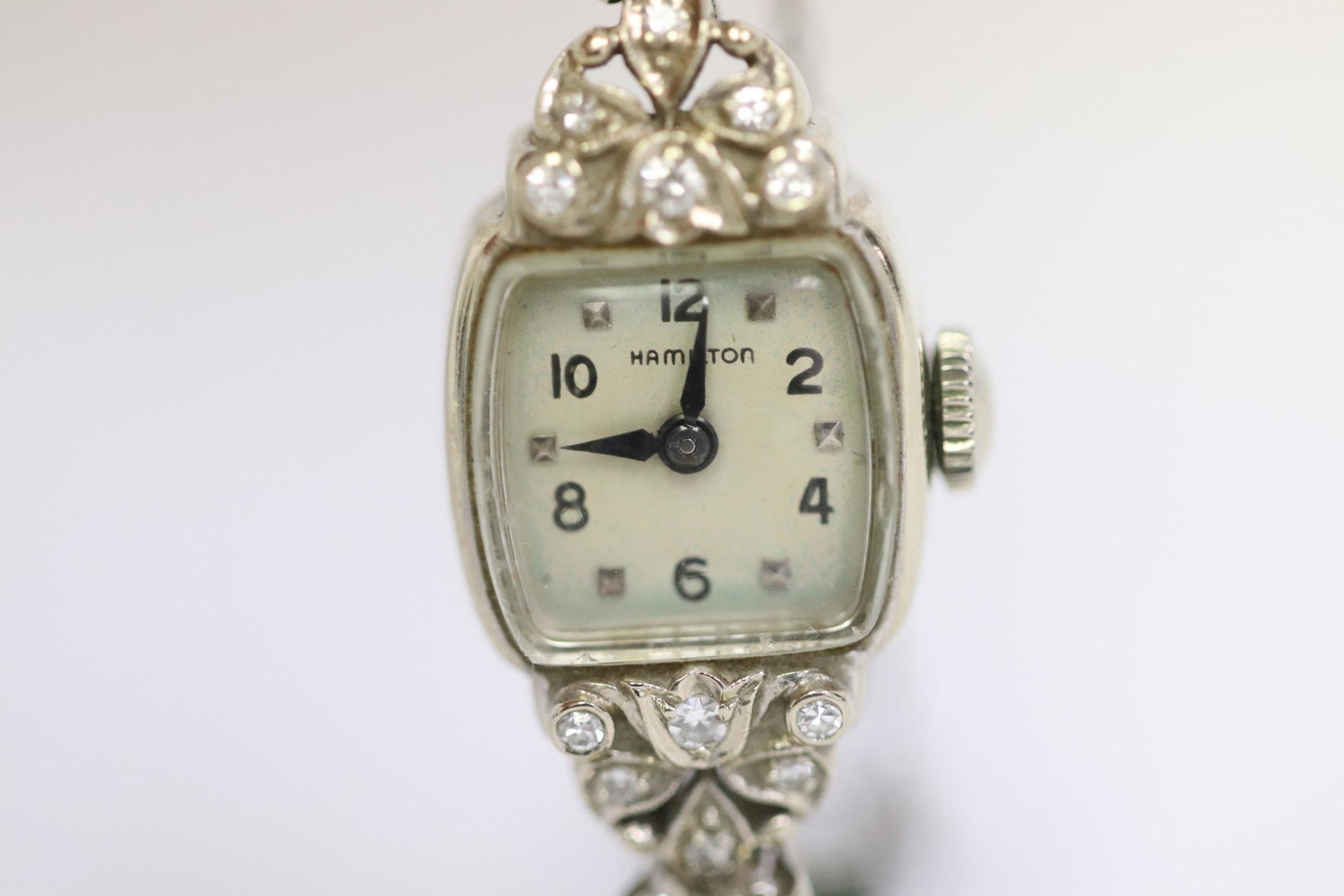 Lady's 14K wrist watch by Hamilton w/ diamonds: Lady's 14K W/G wrist watch by Hamilton, the band is also 14K W/G, the clasp is a gold filled replacement, decorated with small diamonds, tdw approx. 0.40ct, wt. 15.5gm