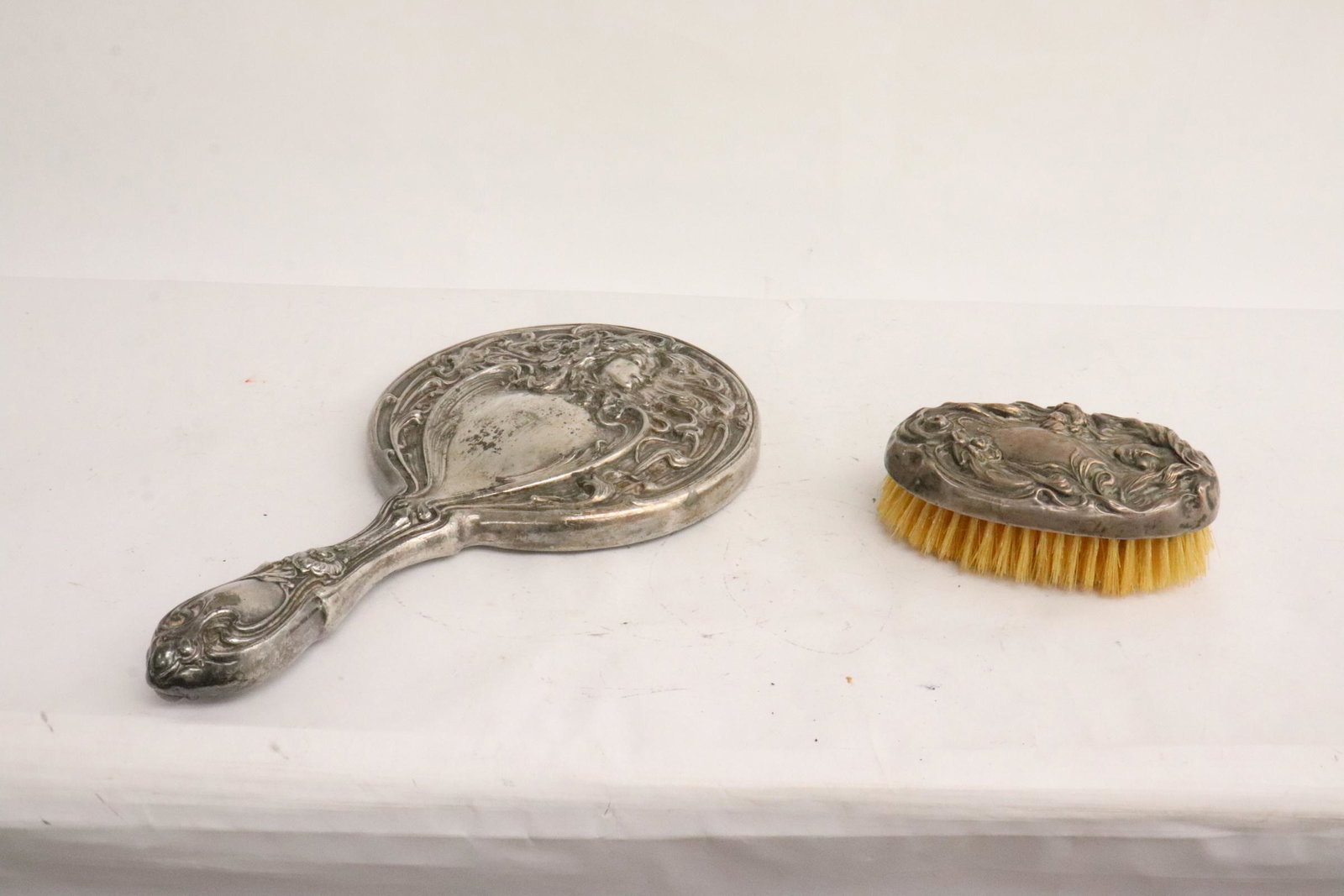A silverplate hand mirror, and a sterling hair brush: A beautiful art nouveau silverplate hand mirror (1.7"x4.4"x2.8"), and a sterling art nouveau hair brush (10.2"x5.7"x1.2")