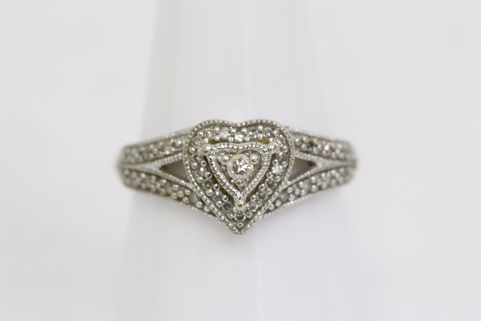 10K W/G diamond ring in heart motif: 10K W/G diamond ring in heart motif, set with small diamonds, tdw approx. 0.30ct, wt. 3.2gm, size 7