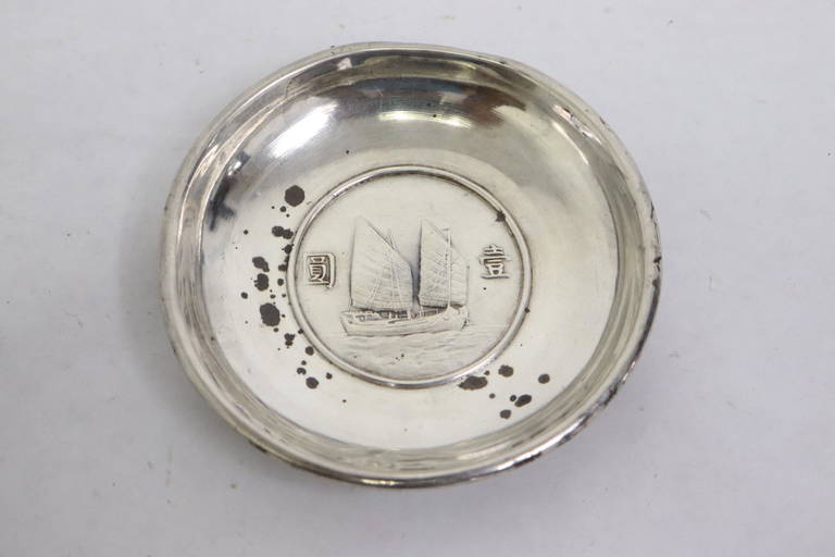 A small silver plate with a coin at center Jun 20, 2022