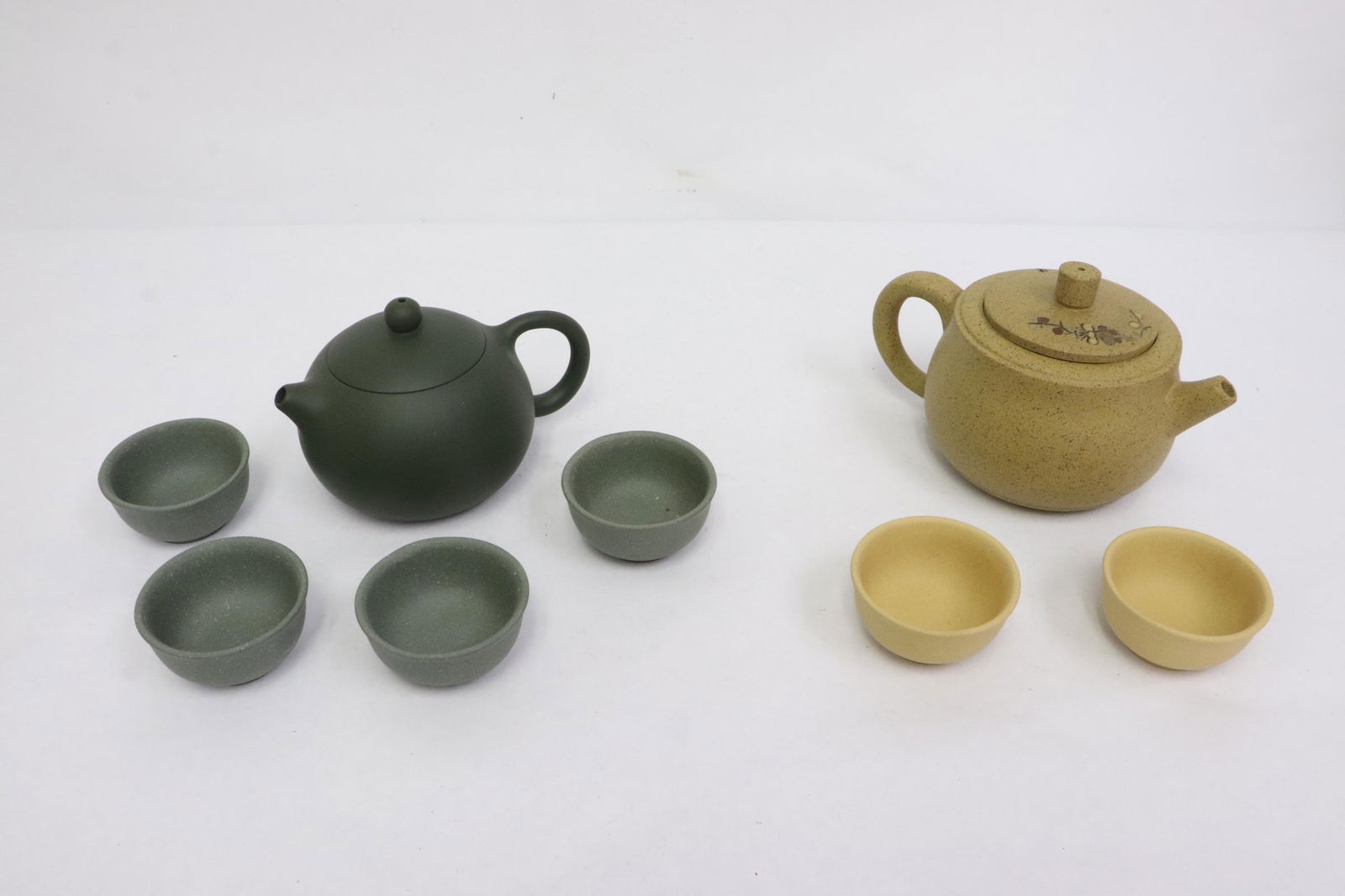 2 Yixing tea sets: 2 Yixing tea sets (teapot: 3.1"x4.8"x3.6", 3.3"x5.6"x3.9") (cup: 1.1"x2.15"dia (4), 1.1"x2.2"dia(2))
