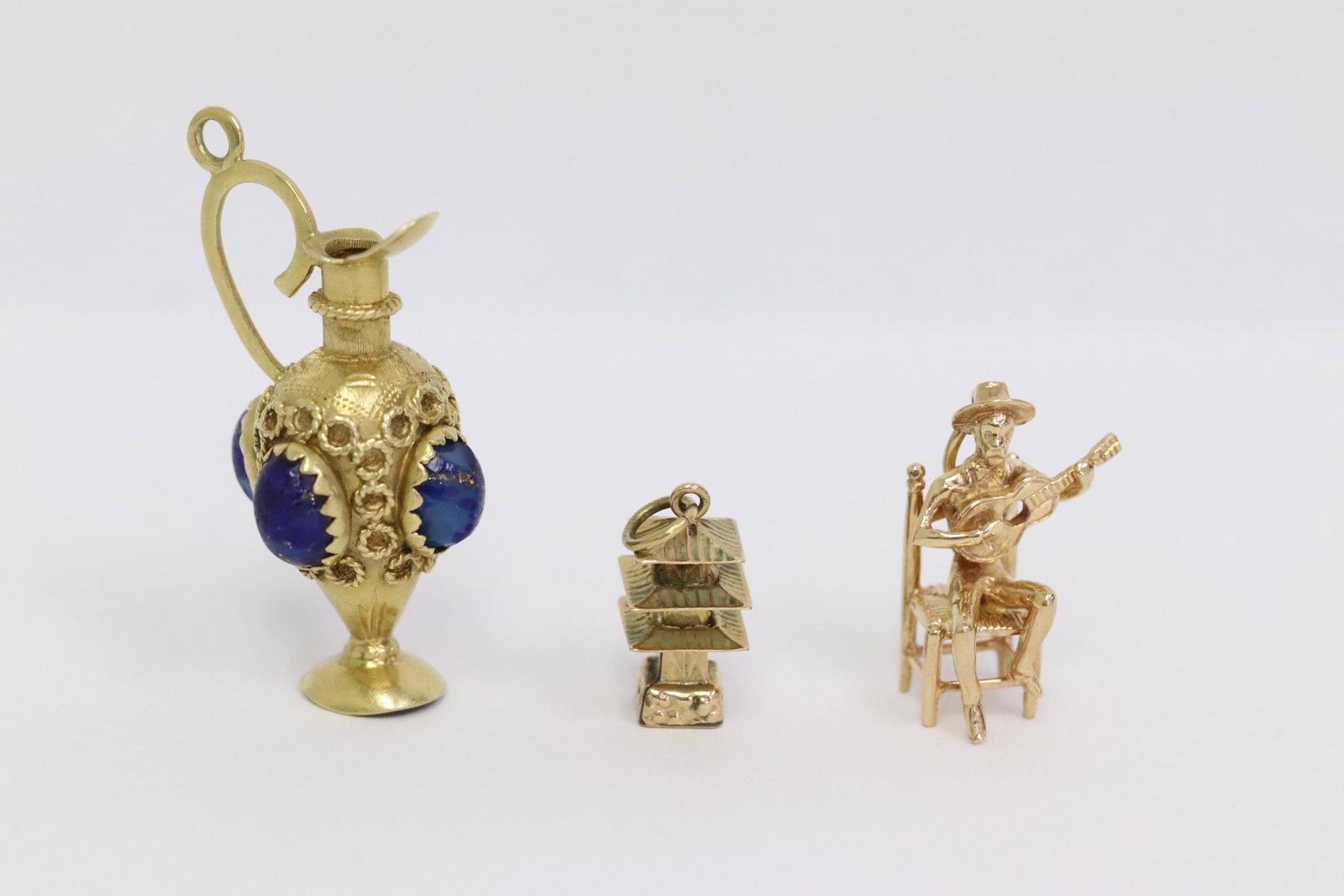 Three 14K Y/G charms: Three 14K Y/G charms (0.75"L - 1.5"L), wt. 13.6gm
