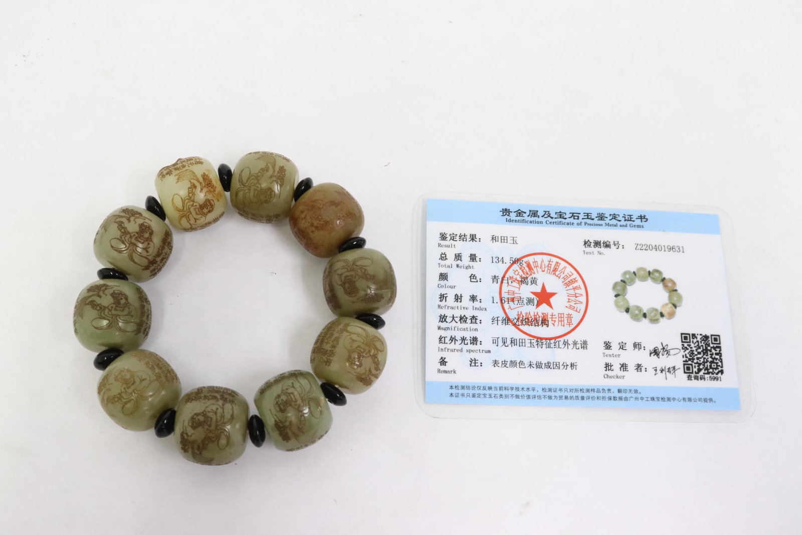 A jade bead bracelet with calligraphy: A jade bead (0.65"x0.75"dia) bracelet with calligraphy