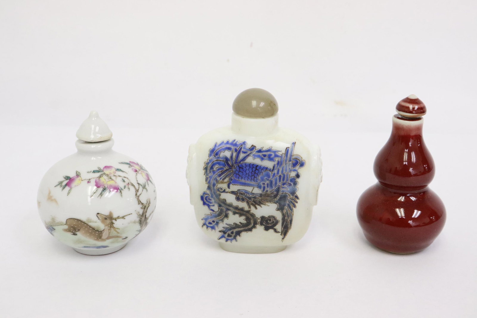 3 snuff bottles: 2 porcelain snuff bottles (2.8"x2.3"dia, 3.1"x1.7"dia) and an enamel on Peking glass bottle (3.3"x2.6"x1.3")