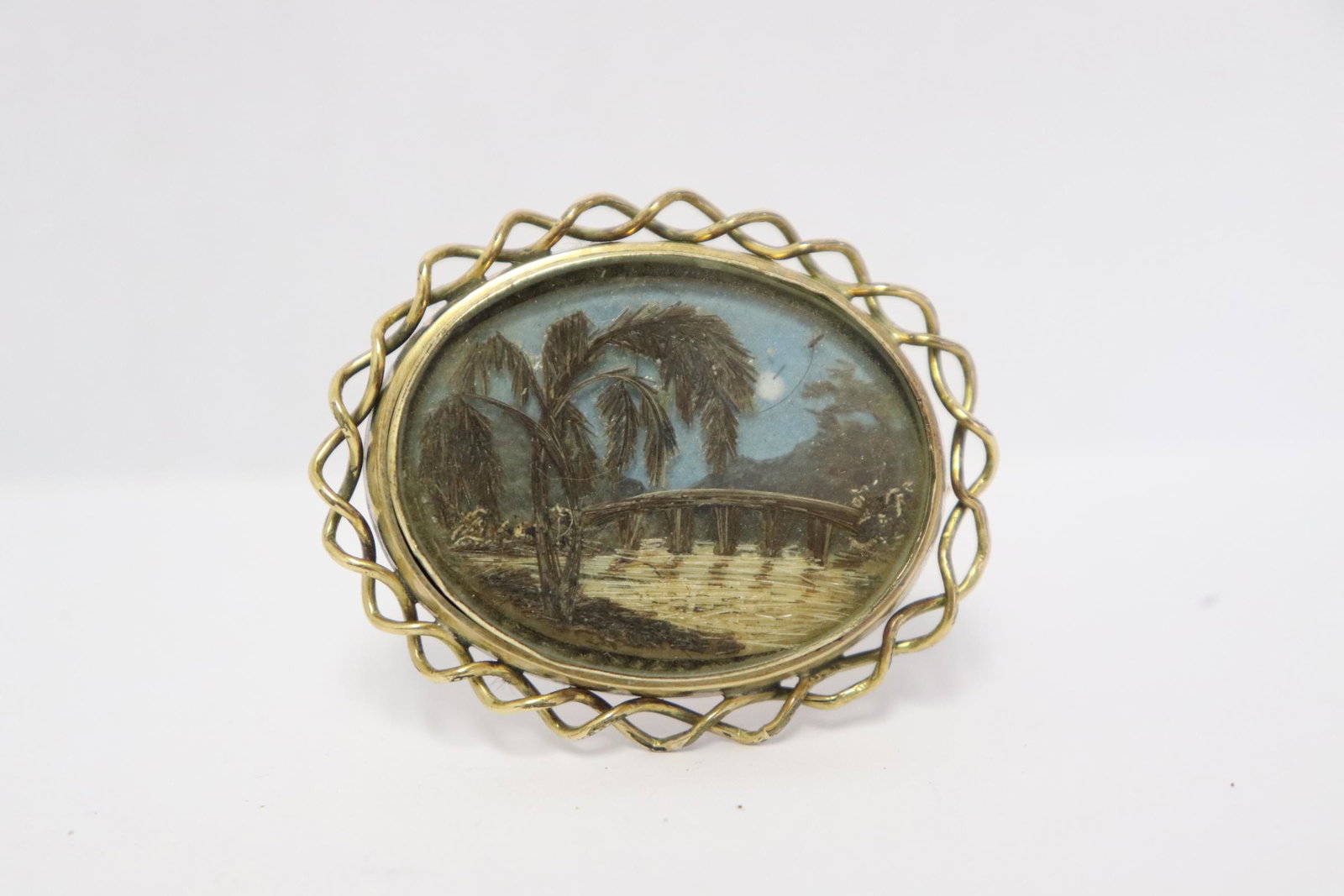 Victorian gold filled hair mourning brooch: Victorian gold filled hair mourning brooch (1.4"x1.75") to depict river scene with bridge, wt. 11.9gm