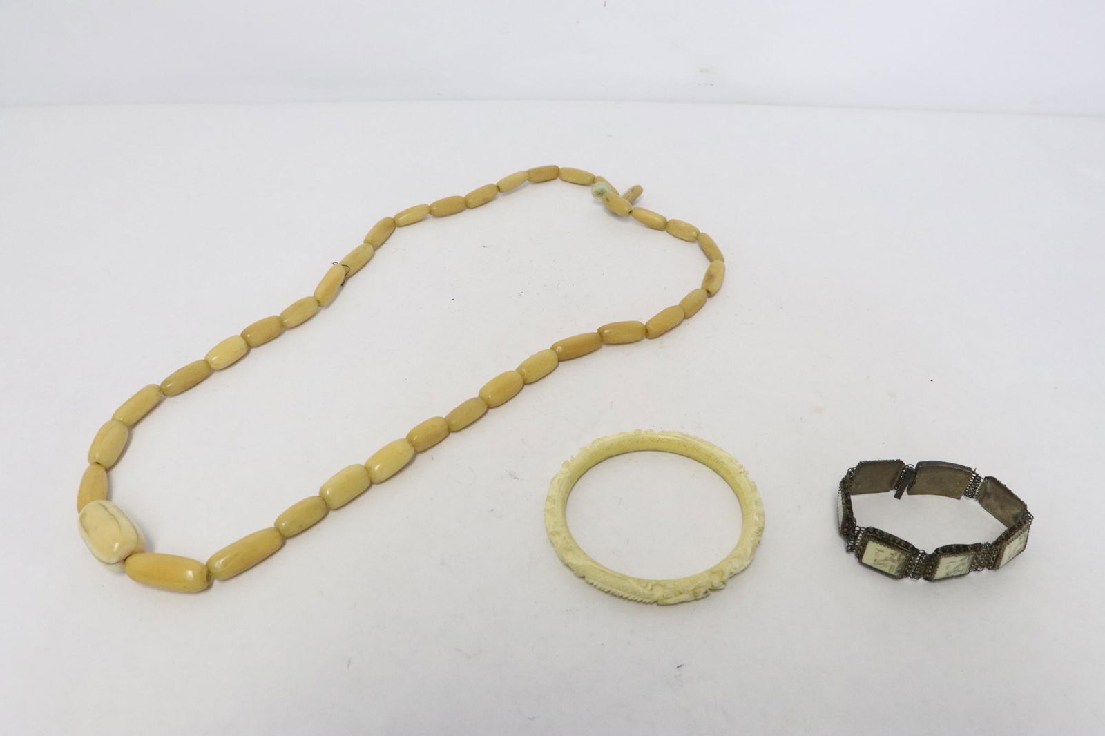 3 pieces: 3 pieces; Chinese bone carved bangle (0.35"x3.18"dia), antique silver bracelet (7"L) with bone plaque (need repair), and a bone bead necklace (need re-strung)