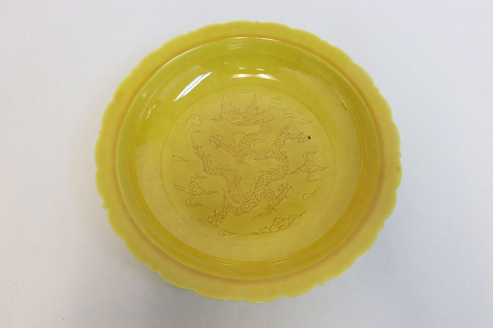 Yellow glazed porcelain plate: Yellow glazed porcelain plate embossed with dragon motif decoration, 1.95"x8.96"dia
