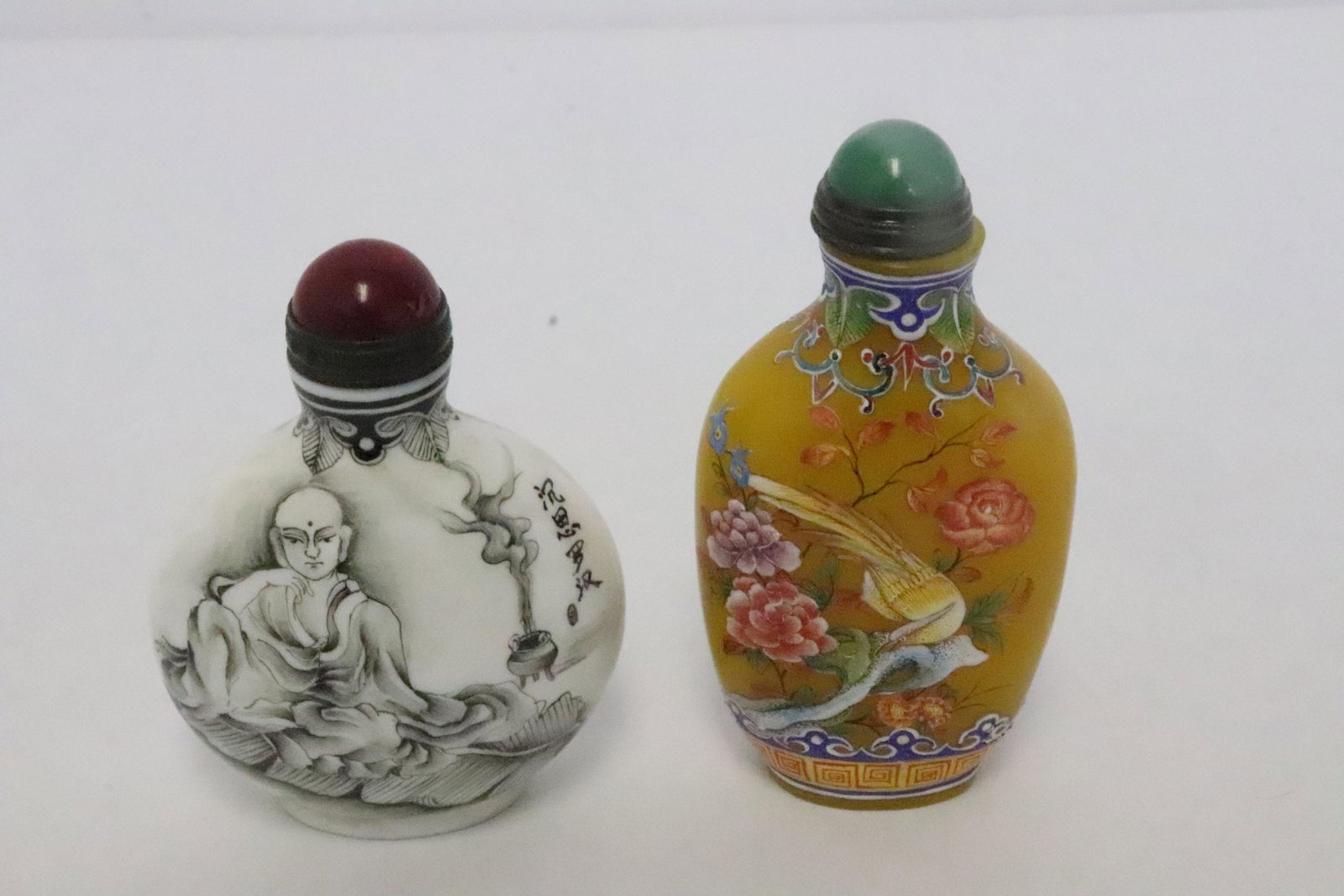 2 snuff bottles: 2 snuff bottles; one enamel on Peking glass (3.25"x1.65"x0.85") and a porcelain bottle (2.75"x2"x1.15")