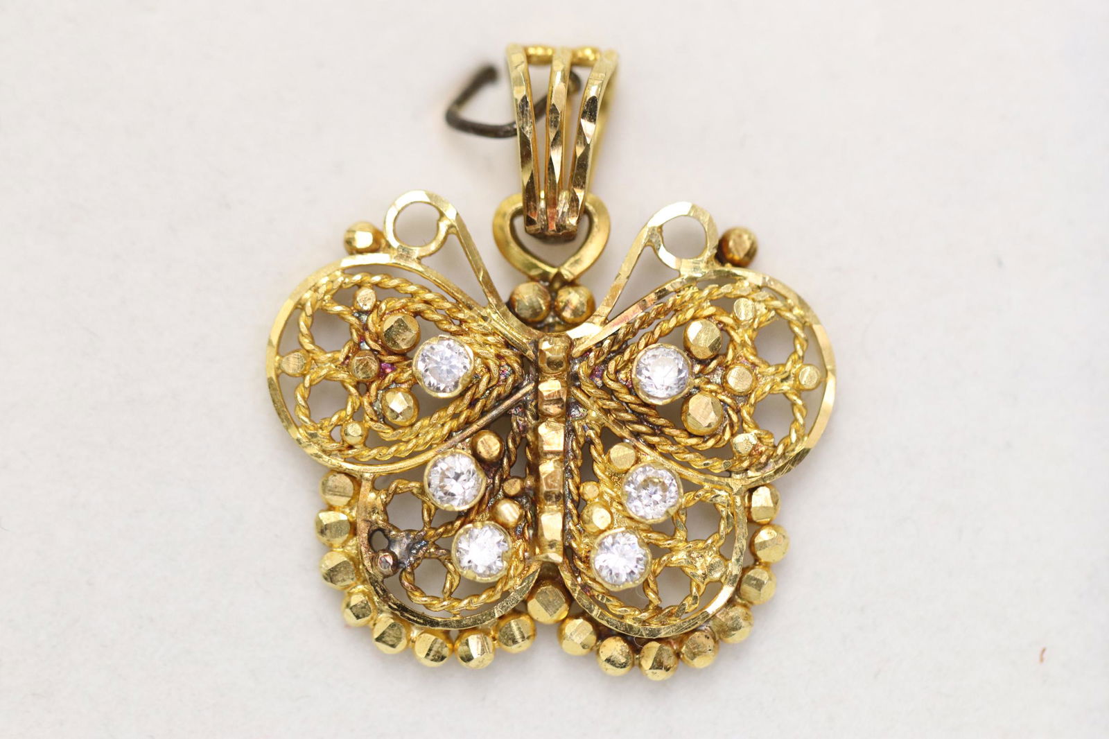 A 22K Y/G butterfly motif pendant w/ clear stones (1 of 7)