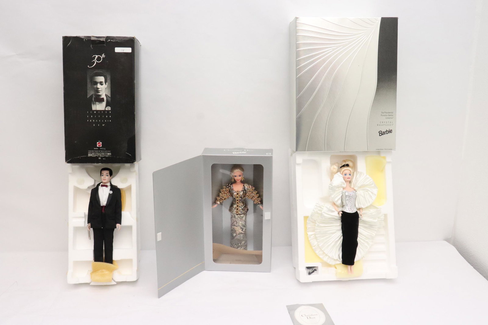 3 dolls: 3 dolls; a Rhapsody porcelain face Barbie doll (13"H), a Christian Dior Barbie doll (11.7"H), and a 30th anniversary Ken doll (12.9"H)