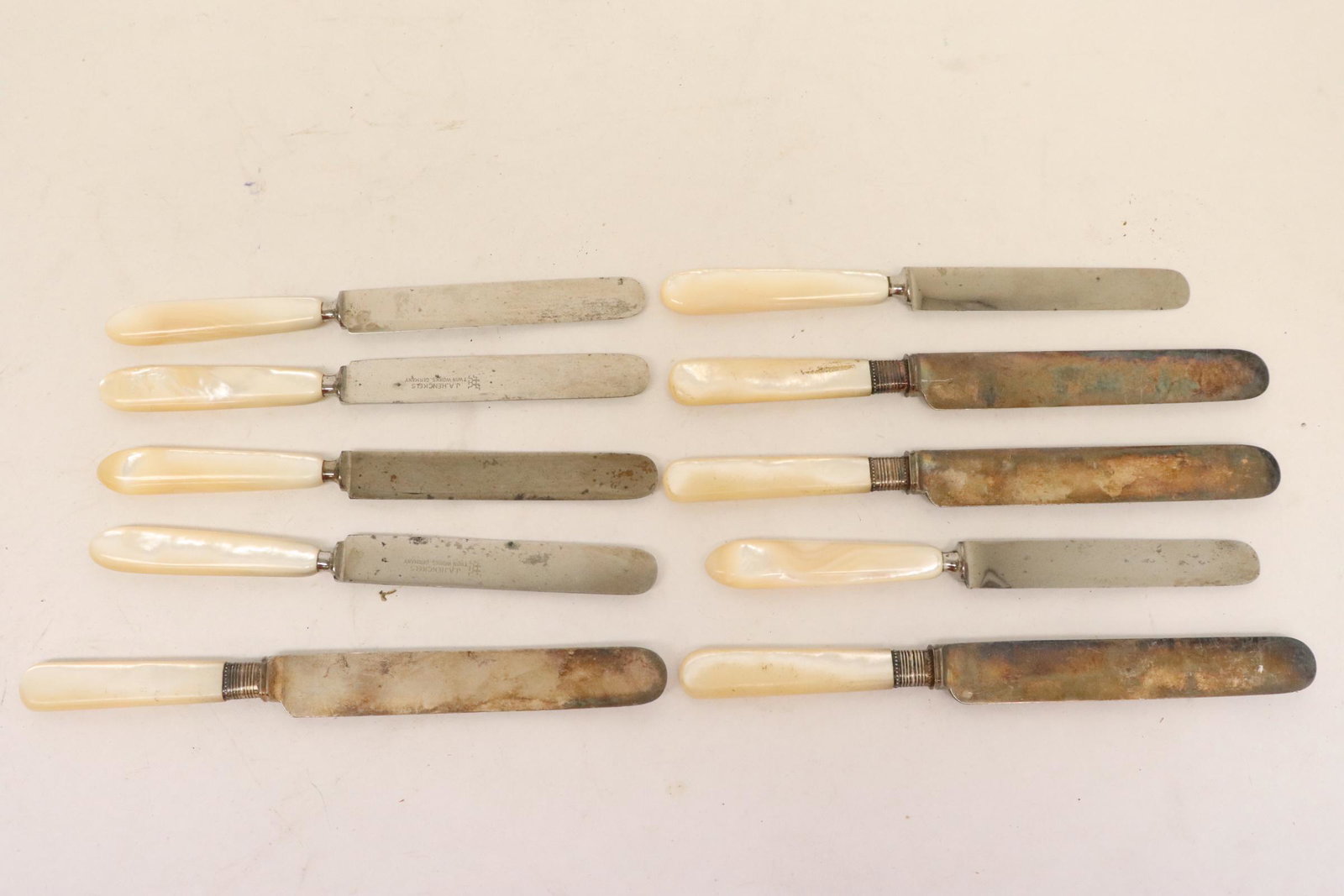 10 fish knives: 6 antique J. A. Henckels fish knives (9"L), and 4 Meriden fish knives with MOP handles (8.05"L)