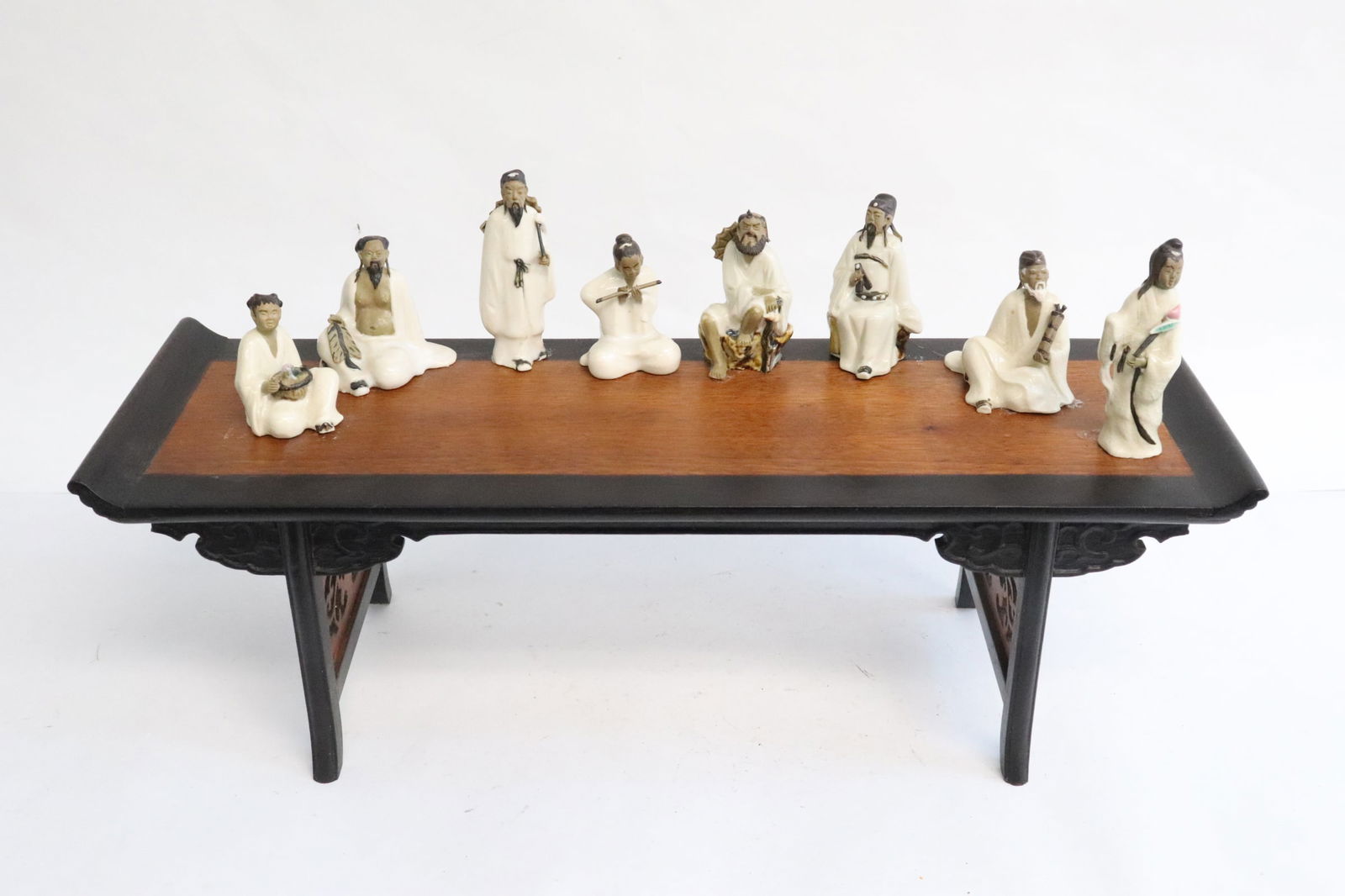 8 earthenware figurine on zitan platform: 8 earthenware figurines (1.7"H - 2.7"H) of 8 immortals on zitan platform stand (4.75"x14.25"x4.75")