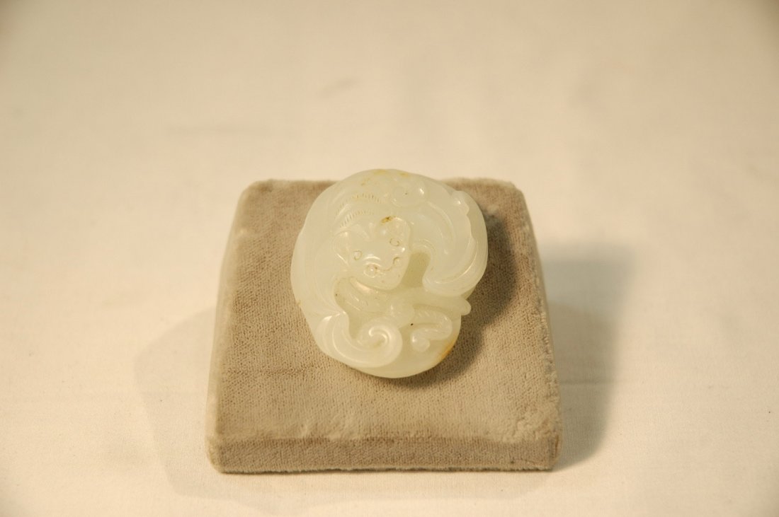 Chinese white jade carved oval plaque: Chinese white jade carved oval plaque carved with a bat holding string connecting to a coin (1.46"Lx1.77"W)