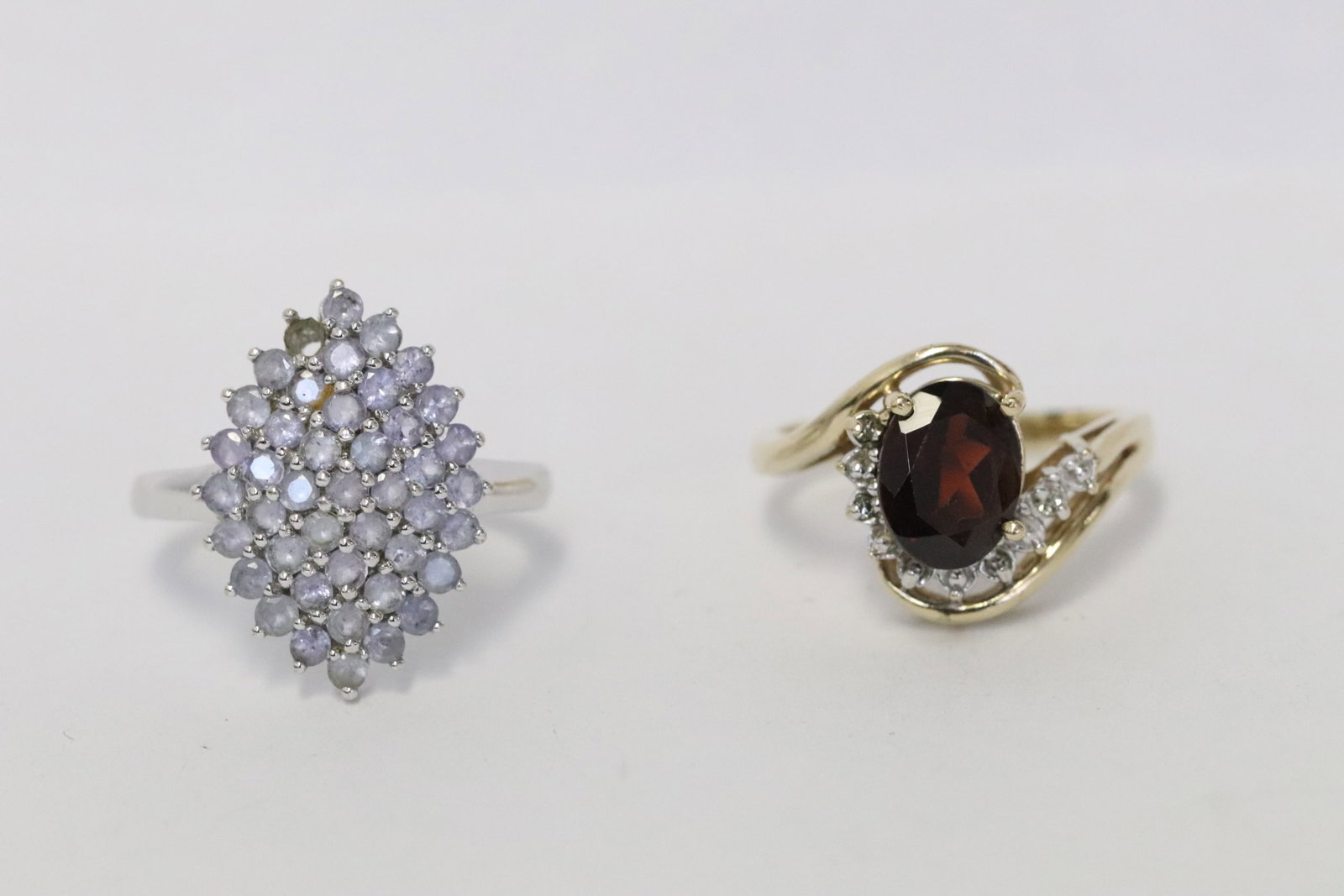 Two 10K rings: Two 10K rings; one set with garnet and small diamonds, size 7, one with clear stones (one stone missing), size 7, total wt. 6.9gm