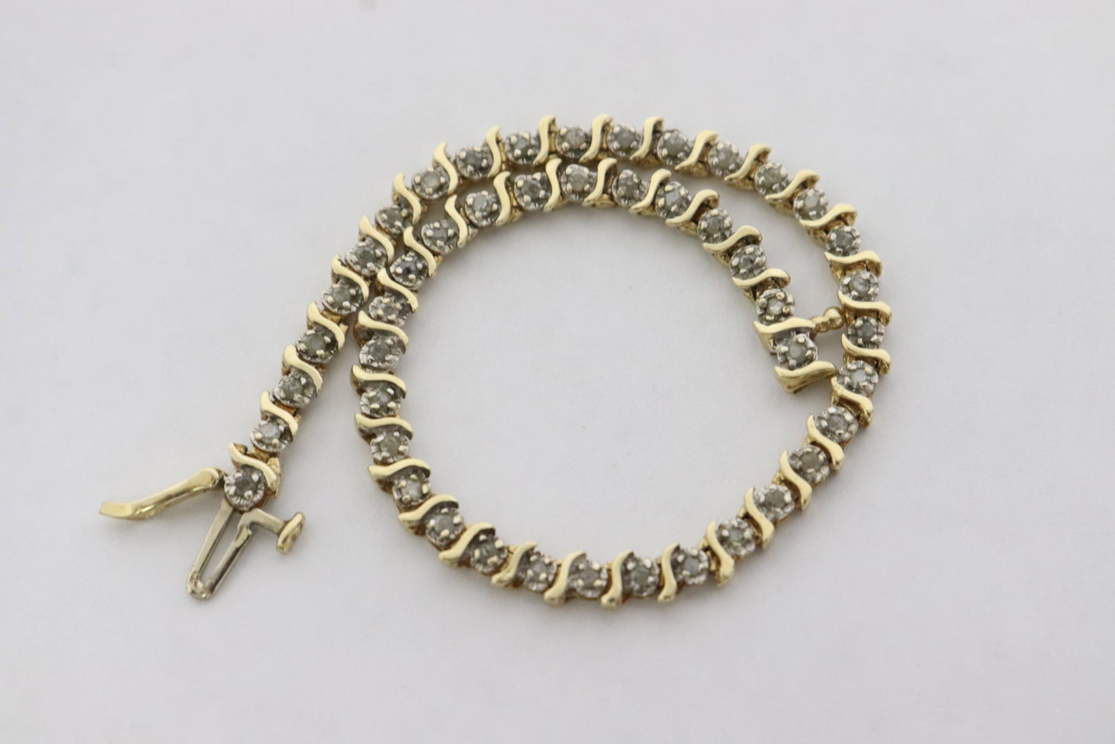14K Y/G tennis bracelet set with diamonds: 14K Y/G tennis bracelet (7.1"L) set with approx. 45 small diamonds, wt. 6.3gm