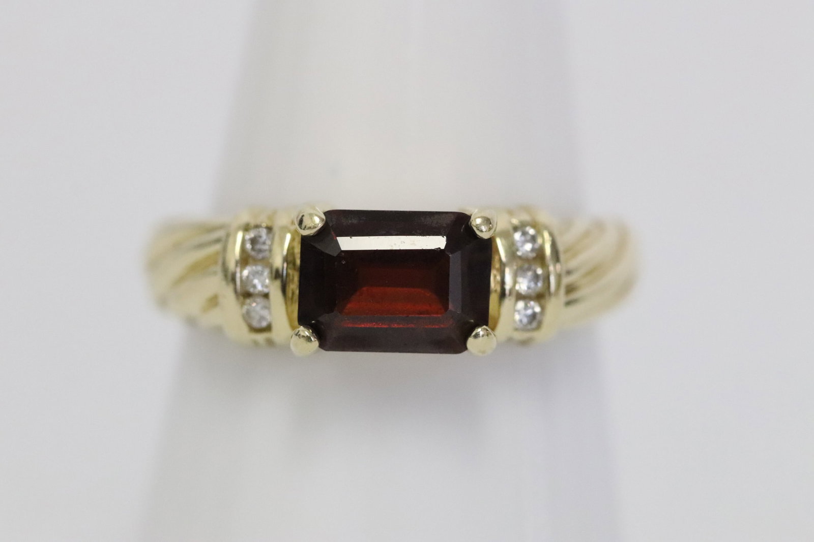 14K Y/G garnet ring accented w/ small diamonds: 14K Y/G ring with garnet and accented with 6 small diamonds, wt. 4.2gm, size 7.5