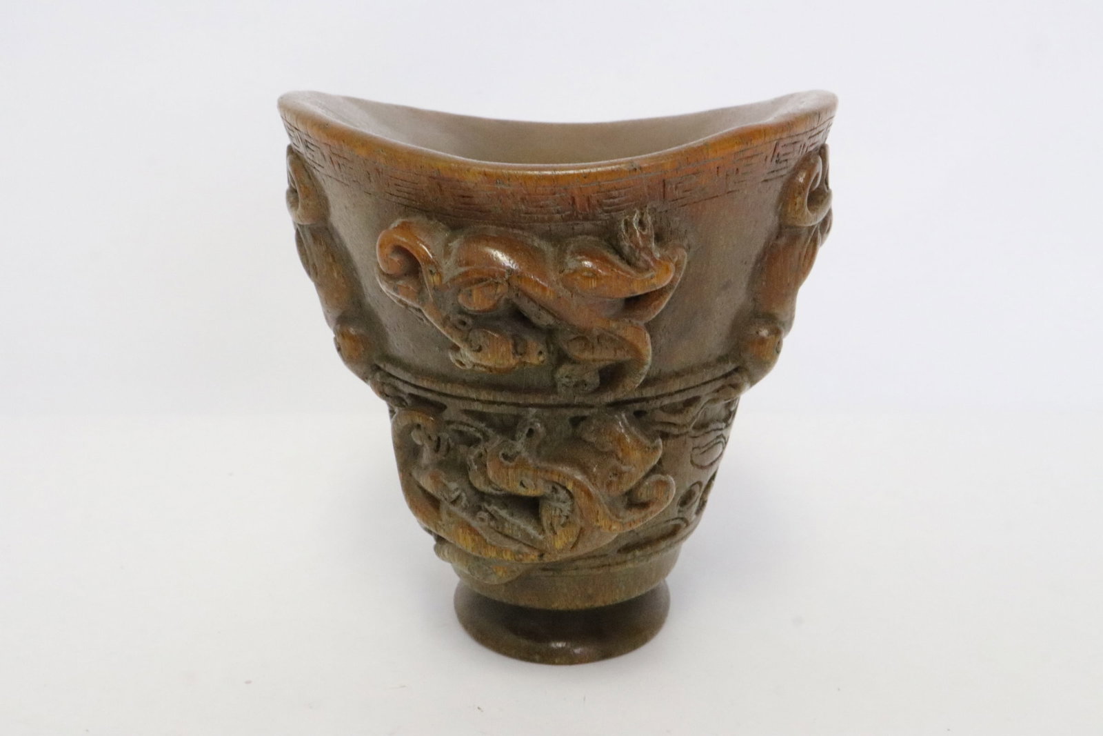 A simulated horn carved libation cup: A simulated horn carved libation cup, 4.7"x5.4"x4.4"