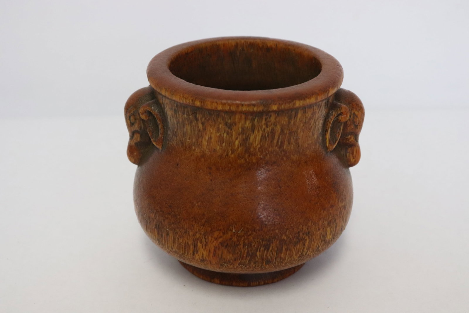A simulated horn carved jar: A simulated horn carved jar with elephant motif handles, 3.95"x4.3"x4.2"