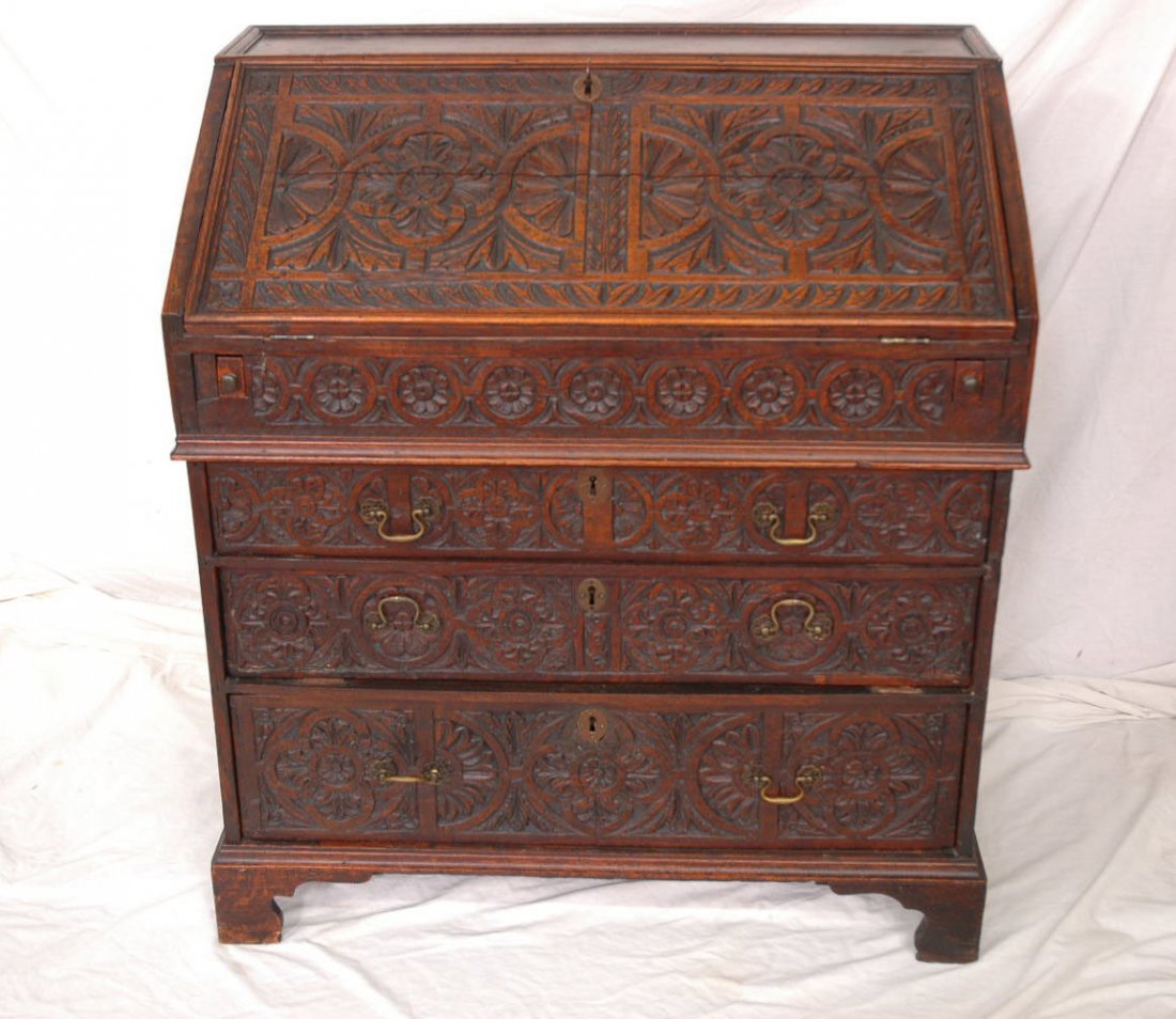 A 17th/18th century English oak slant front desk: An important 17th/18th century English oak slant front desk, the front carved with geometric flower and leave motif in relief. The interior decorated with burl walnut panels (37"x22"x40.5")