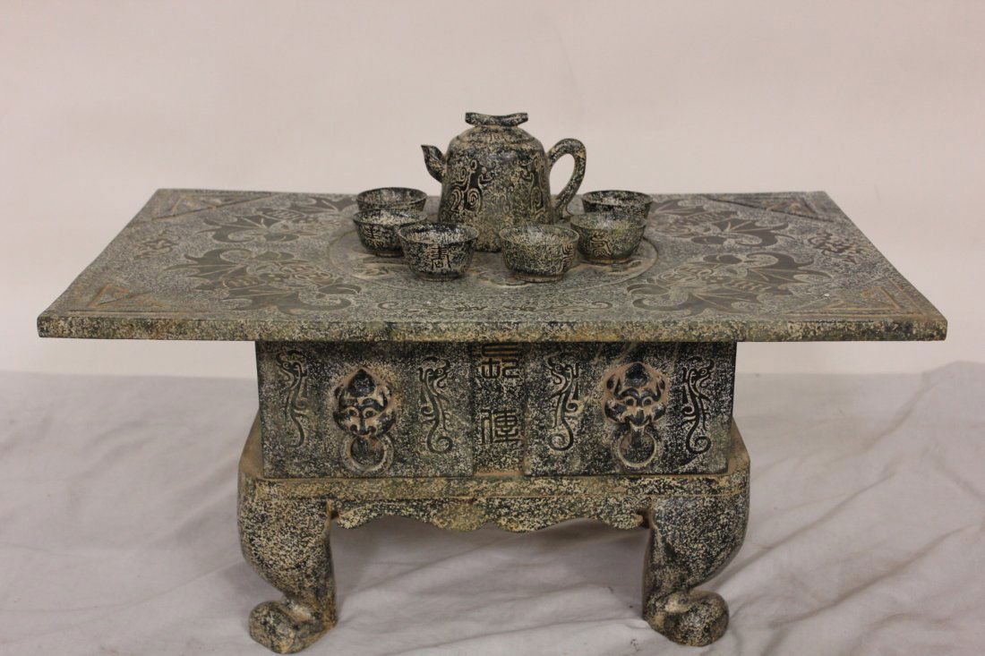 Chinese jade stone carved tea table w/ tea set: Chinese jade stone carved tea table (11"Hx23.5"x15"), top carved with bat motif in relief, together with a teapot (4"H) and 6 tea cups (1.2"H) (one tea cup chip)
