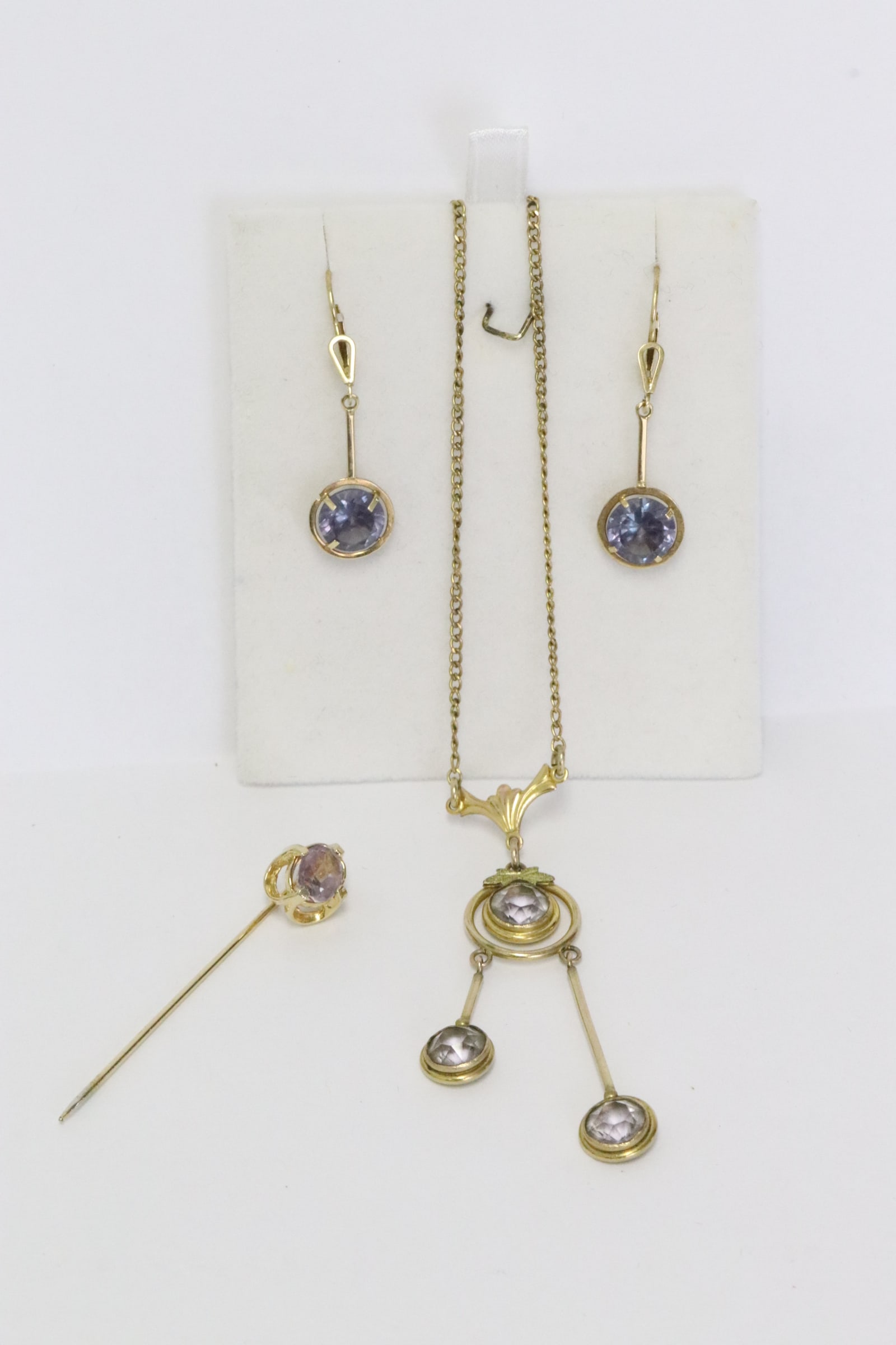 Lot of gold filled jewelry with amethyst like stones: Lot of gold filled jewelry with amethyst like stones; including necklace, pair earrings, and a stick pin