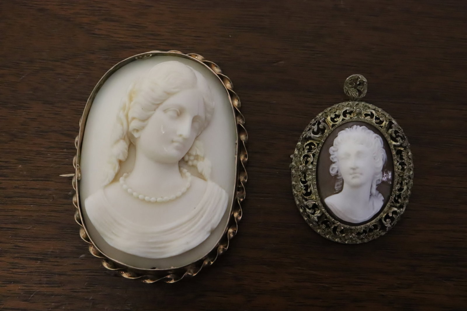 2 pieces; a shell cameo, and a bone carved cameo: 2 pieces; a shell cameo (0.75"x1.6"x1.3"), and a bone carved cameo (0.8"x2.7"x1.95")