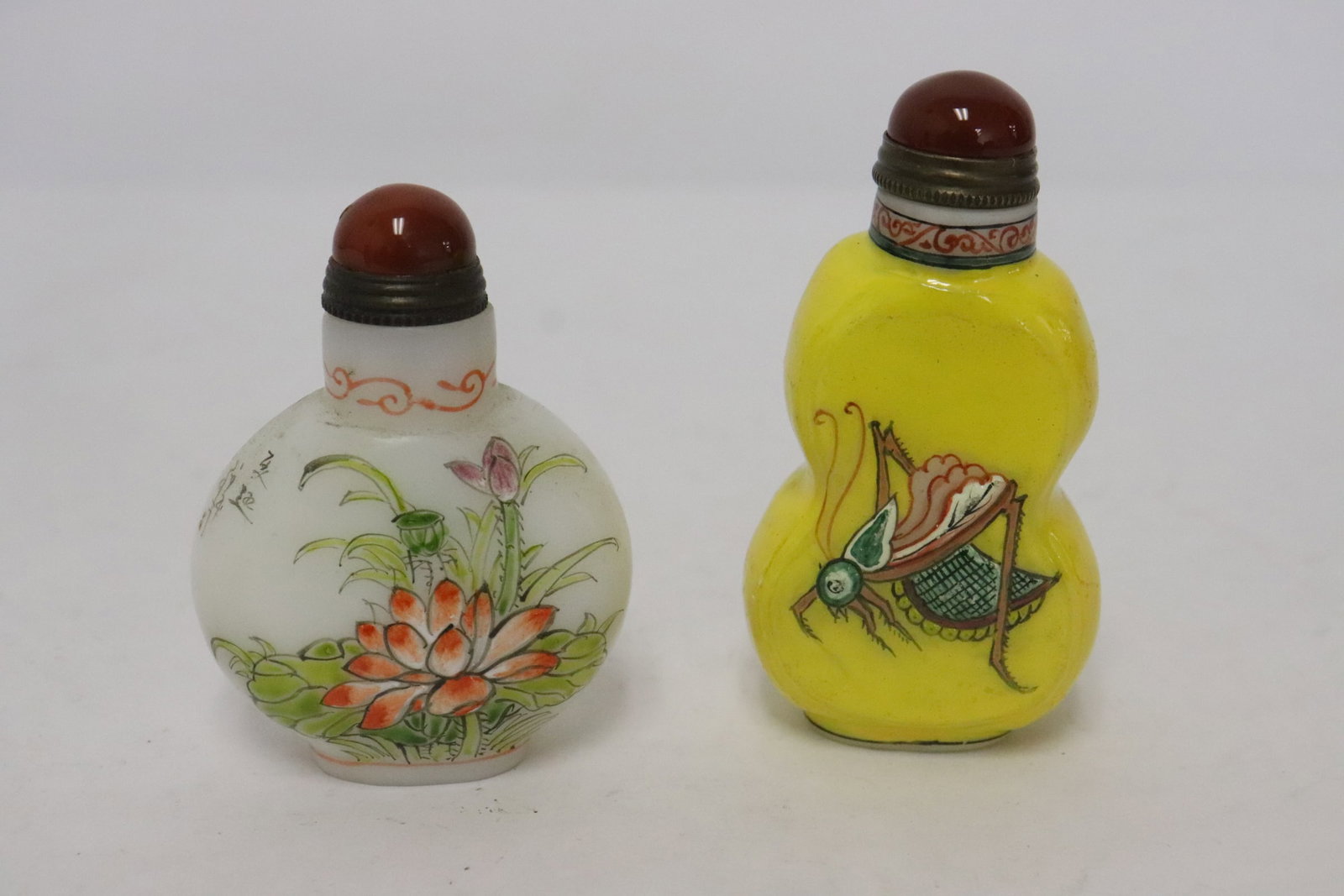 2 enamel on Peking glass snuff bottles: 2 enamel on Peking glass snuff bottles, 2.5"x1.85"x0.9", 2.85"x1.5"x0.8"