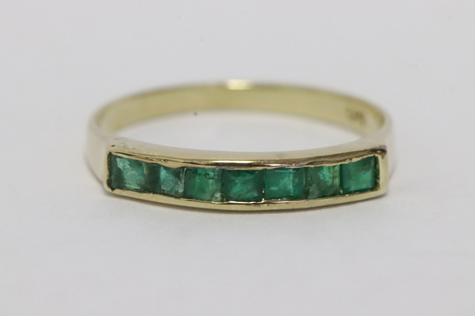 A 14K Y/G emerald band: A 14K Y/G emerald band, wt. 1.5gm, size 6.5