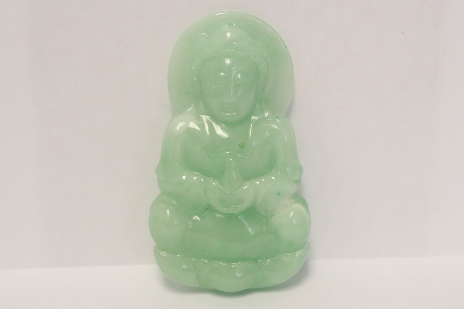 Large Chinese light apple green jadeite carving: Large Chinese light apple green jadeite carving (3.2"x1.85"x0.42") depicting deity motif