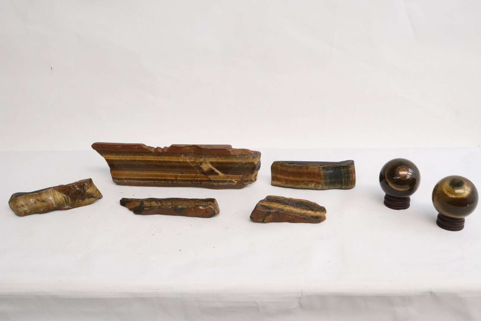 2 tiger eye balls, and 5 tiger eye slabs: 2 tiger eye balls (1.8"x1.8"dia ea), and 5 tiger eye slabs (3.25"L - 8"L)