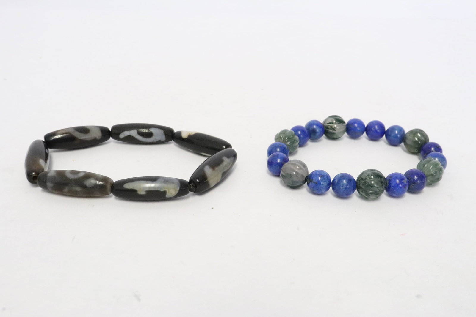 2 bracelets: 2 bracelets; one lapis (0.4"x0.4"dia) and agate (0.45"x0.45"dia), and the other with dzi bead style beads (1.2"x0.4"dia)