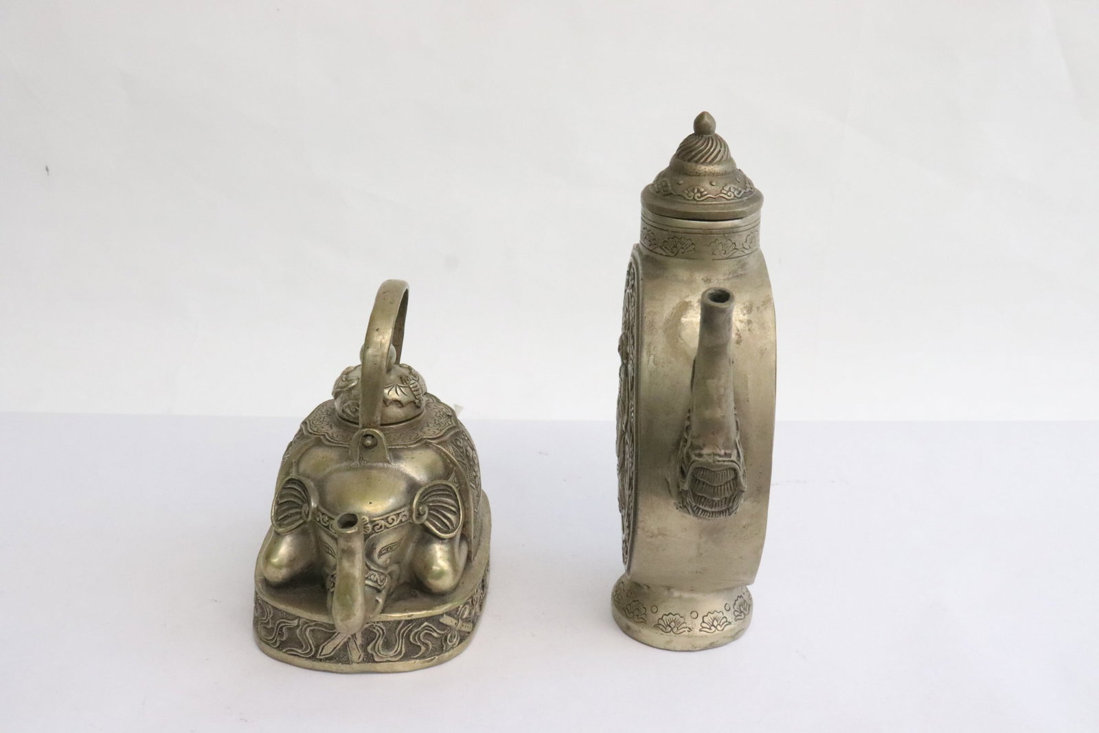 2 white metal pieces; a teapot, and wine server: 2 white metal pieces; a teapot (4.1"x5.25"x3.3"), and wine server (7.5"x6.4"x2")
