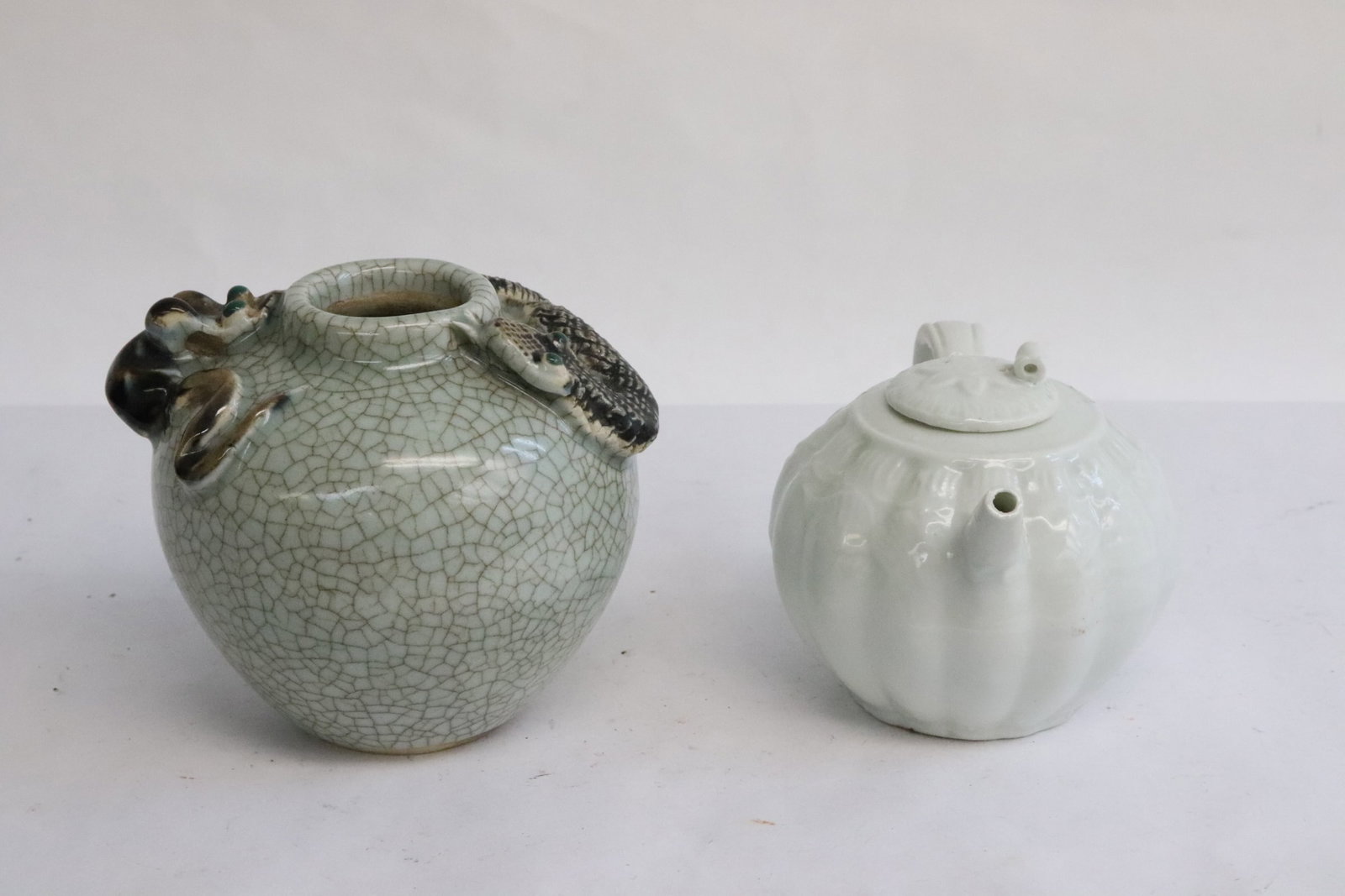 2 pieces: 2 pieces; a white porcelain teapot (3"x4.7"x3.2"), amd a crackleware water dripper with snake motif decoration in relief (3.7"x4.2"x3.8")