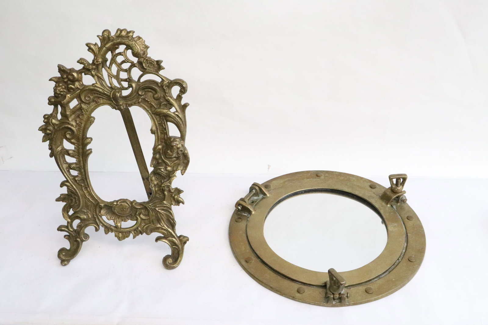 2 pieces; a brass picture frame, and a brass port hole: 2 pieces; a brass picture frame (12"x7.5"), and a brass port hole (2"x10.75"dia)
