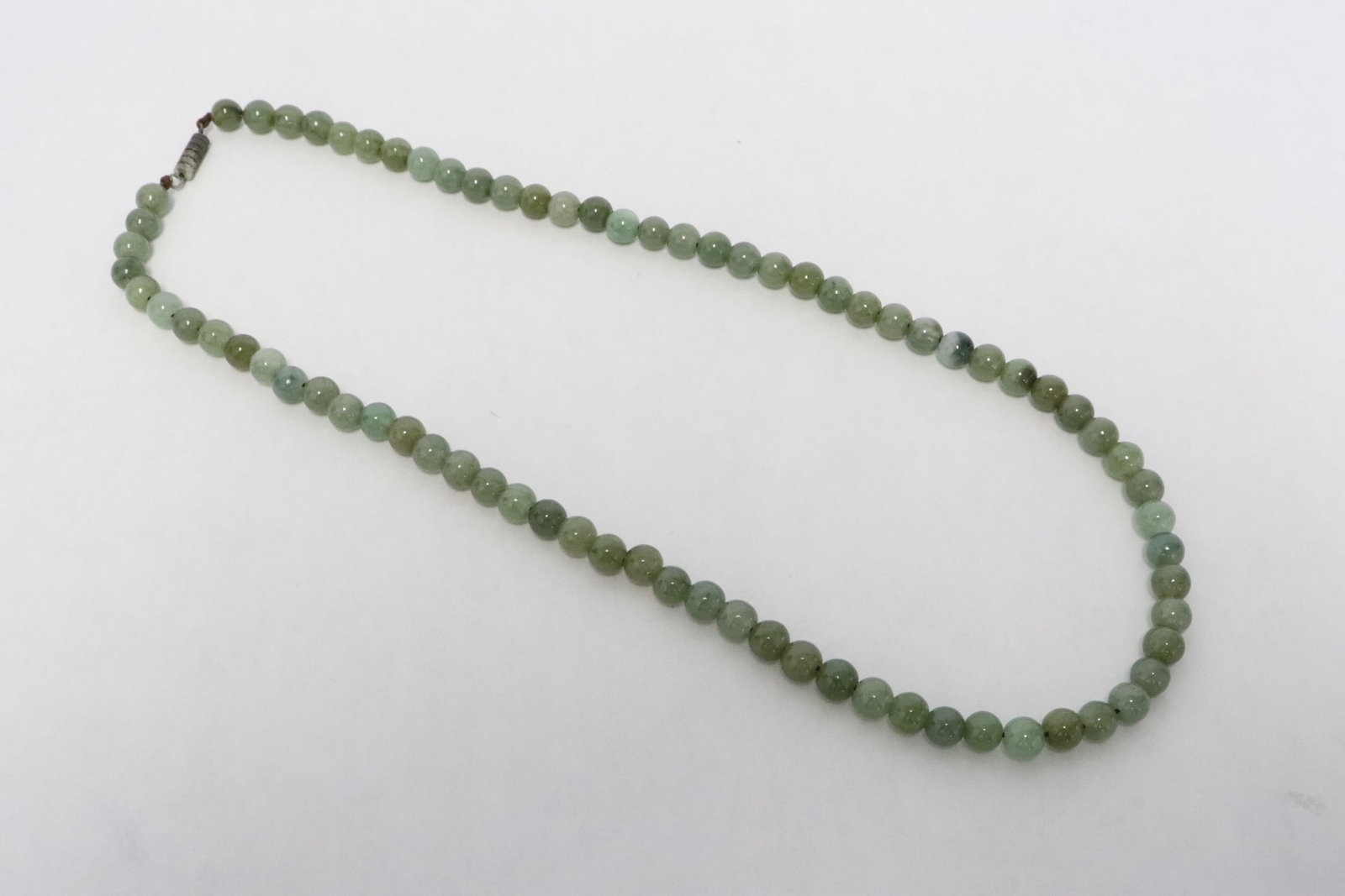 A jadeite bead necklace: A jadeite bead necklace, each bead measures approx. 6.5mm diameter