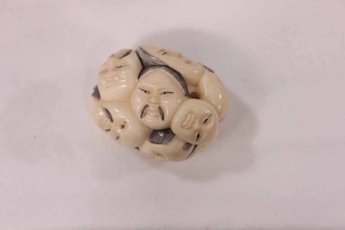 Japanese ivory carved netsuke: Japanese ivory carved netsuke depicting many faces, 1.5"Hx1.3"x1.3"