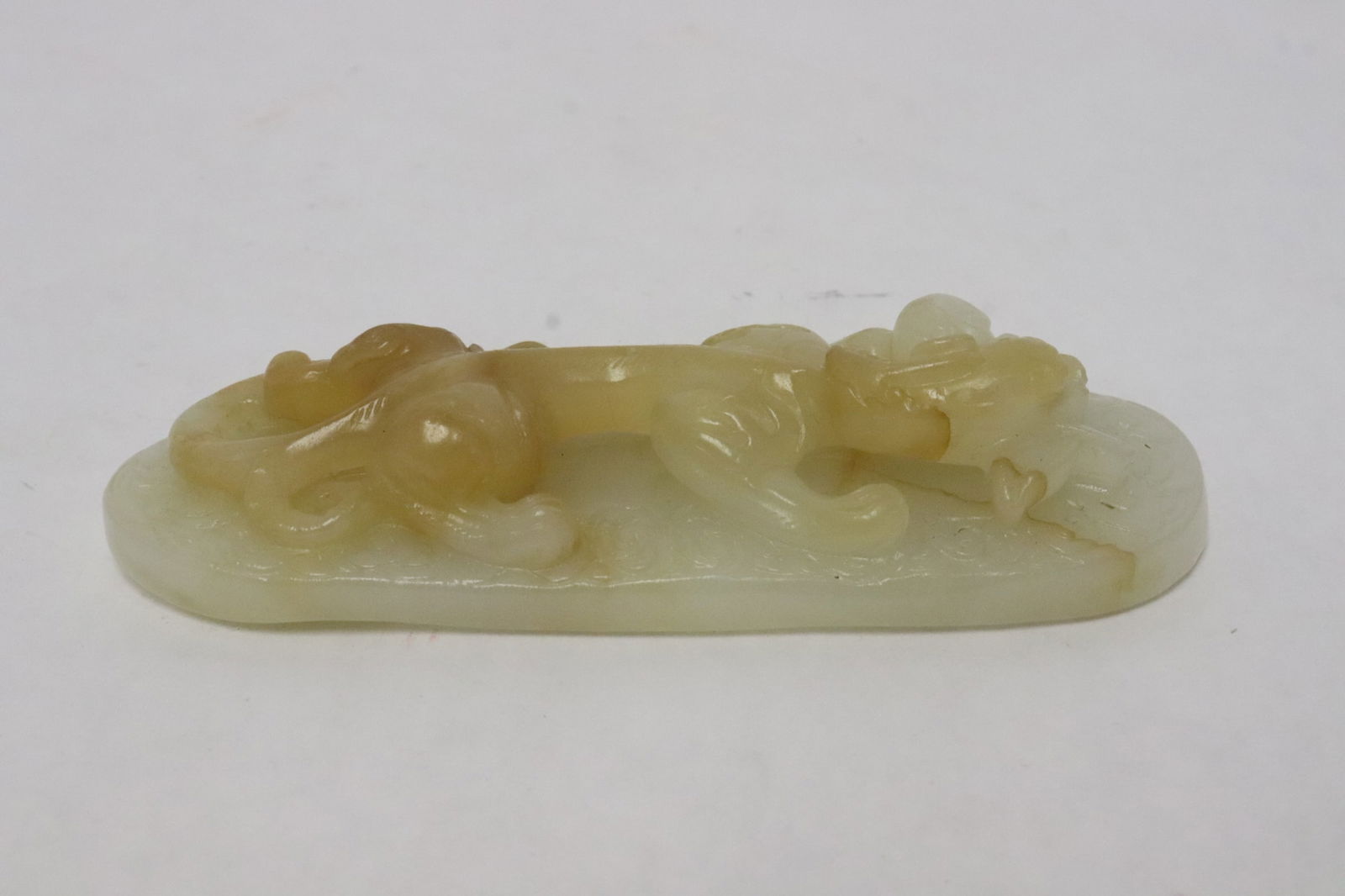 Chinese white jade carved ornament: Chinese white jade carved ornament with qilin motif decoration in high relief, minor natural hairline, 1"x4.5"x1.7"